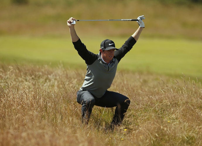 Rory McIlroy loosens up before playing a shot from the fescue on the seventh hole.