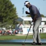Vijay Singh pumps his fist after making a putt.