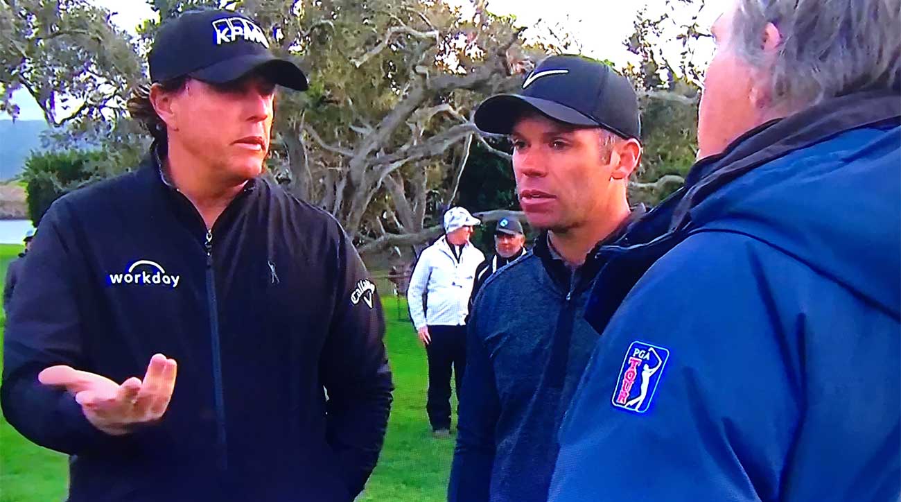 Phil Mickelson and Paul Casey talk with rules official Mark Russell.