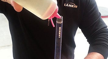 man pouring solvent into gold club grip