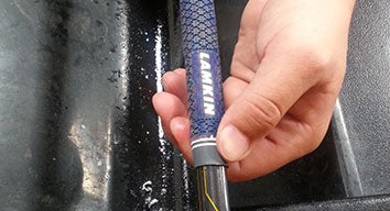 man sliding new grip into golf club