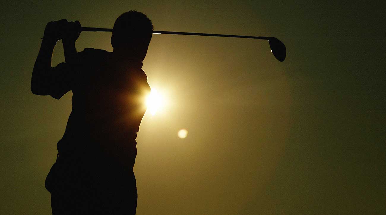 Man hits driver on golf course.