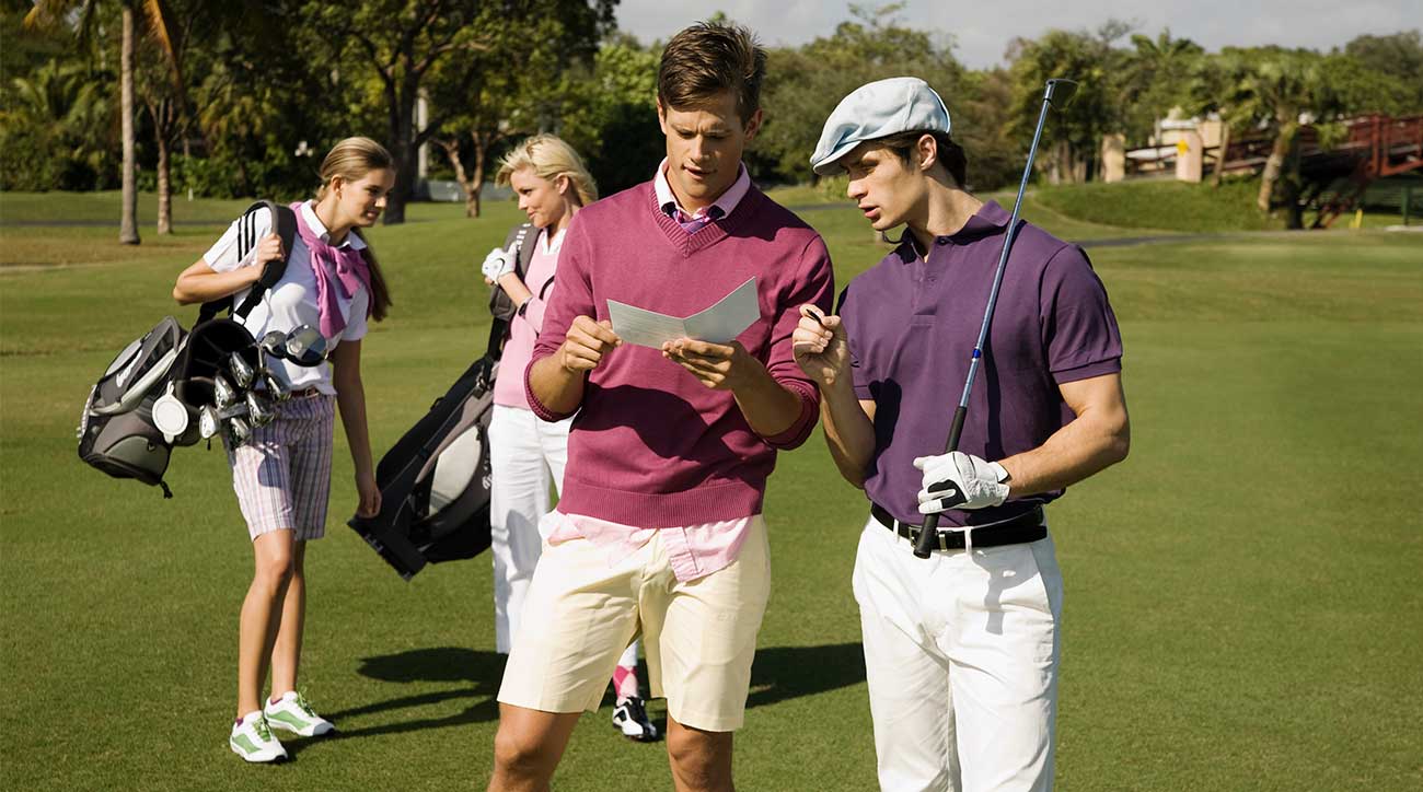 Junior golfers look at their scorecard on the golf course.