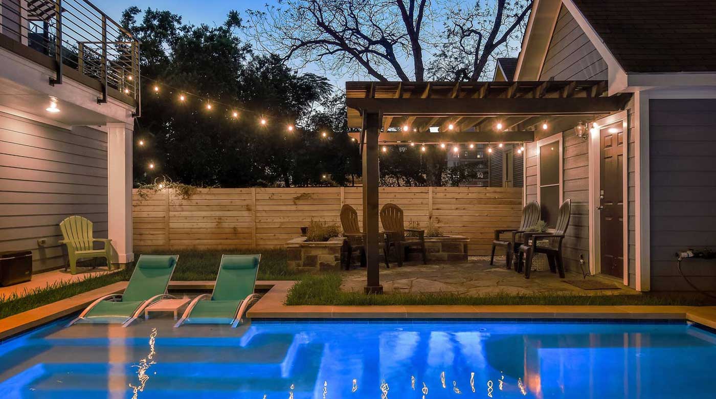 Well lit pool area in the backyard of a Texas home.