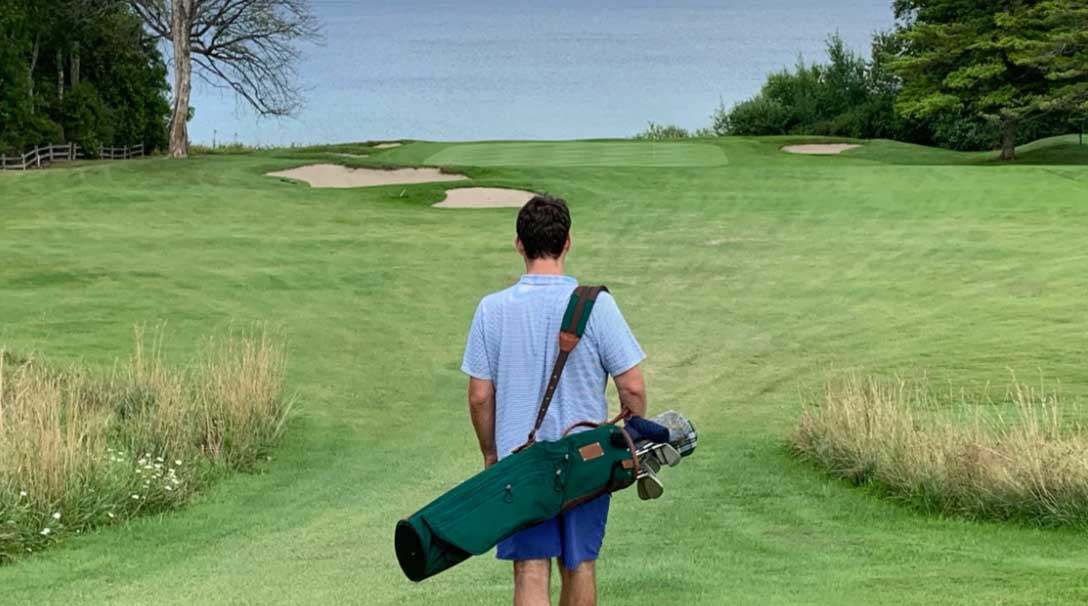 Golfer walking with Shapland golf bag