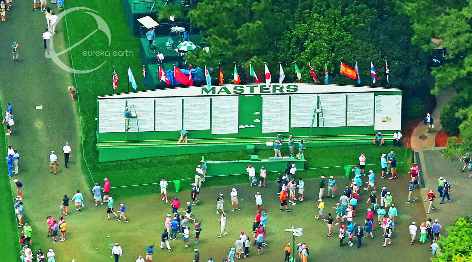 Patrons congregate by the leaderboard next to the 1st fairway.