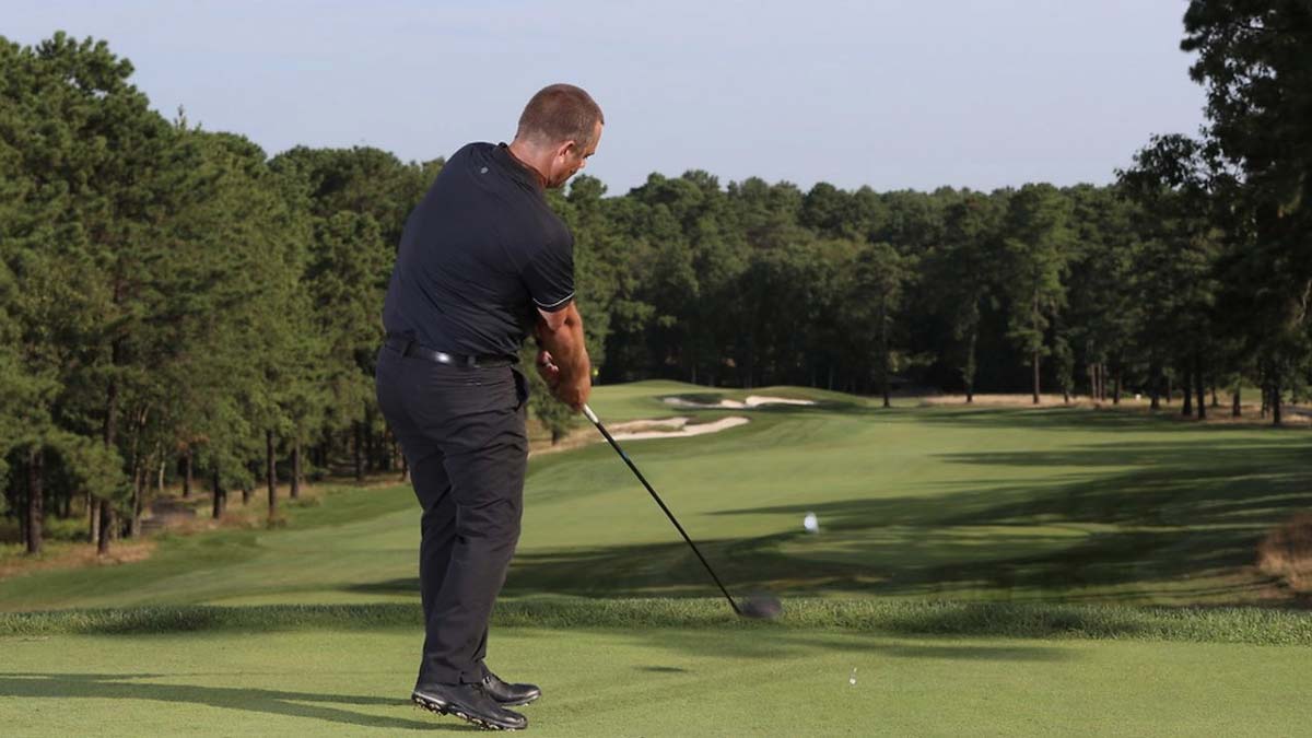 Golf instructor swings driver