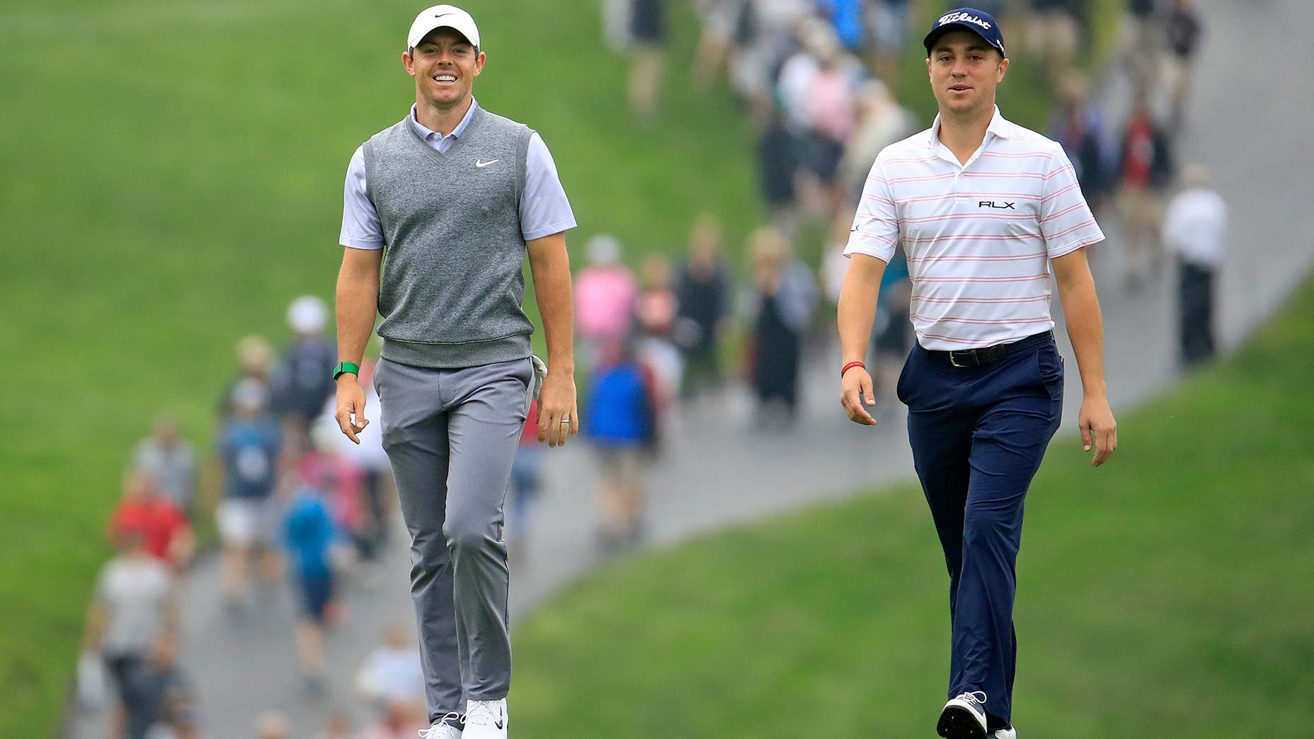 Rory McIlroy and Justin Thomas walk up the fairway.