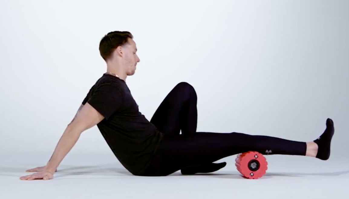 Man using foam roller to loosen calf muscle.