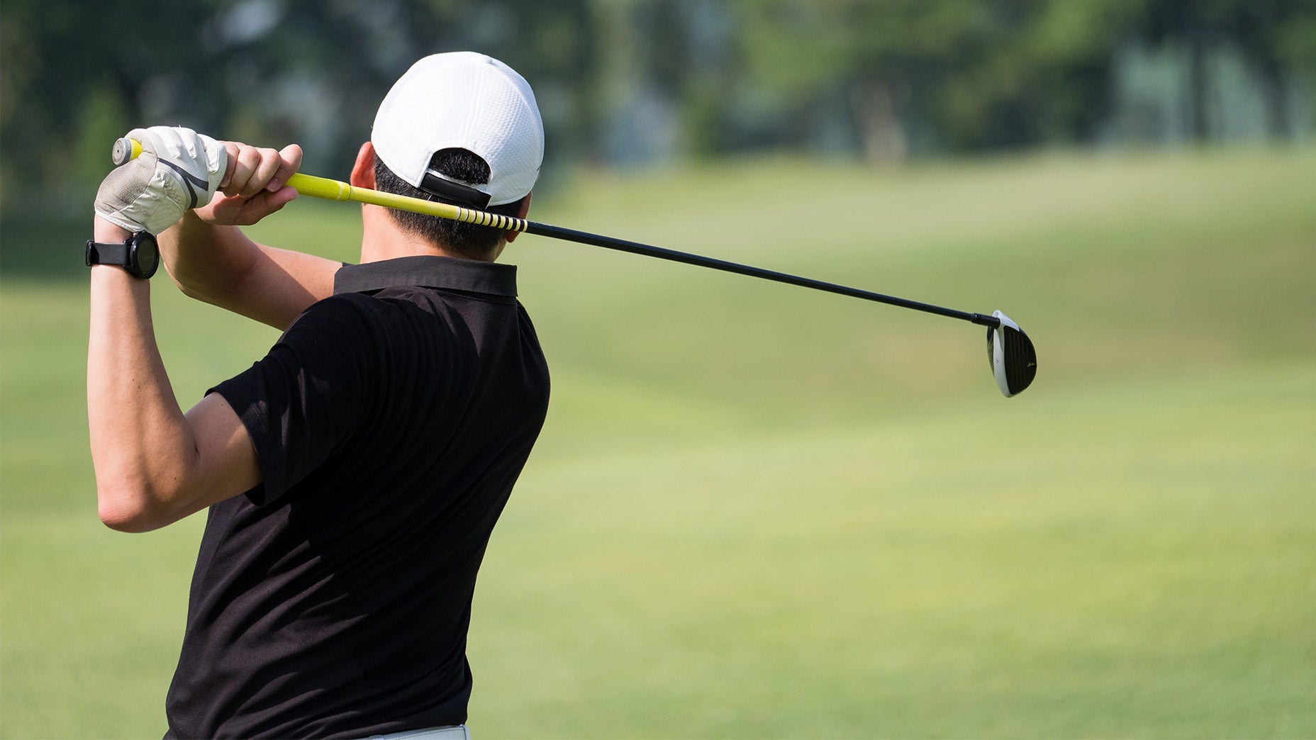 A golfer makes a swing.