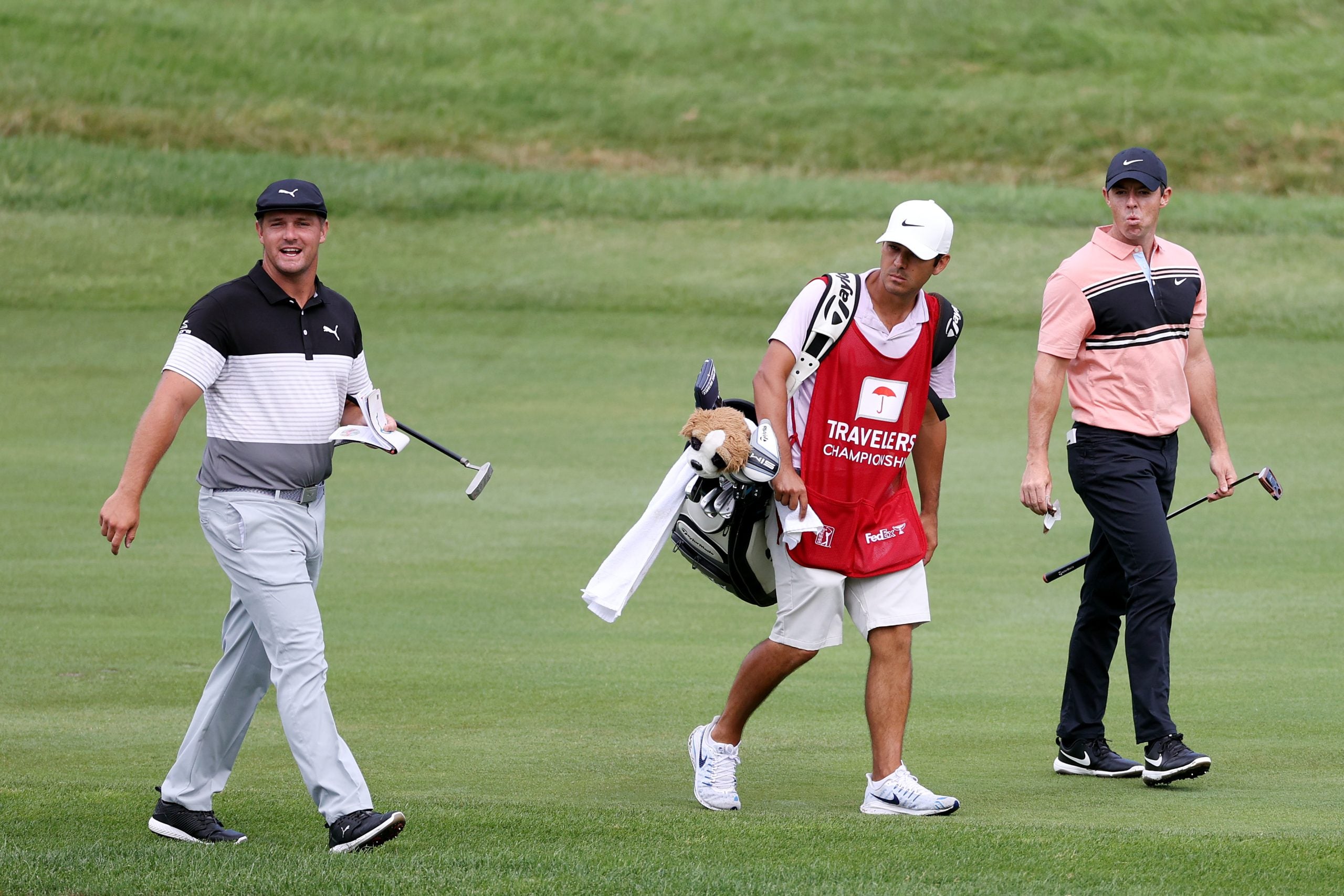 Bryson DeChambeau and Rory McIlroy walk down the fairway together.