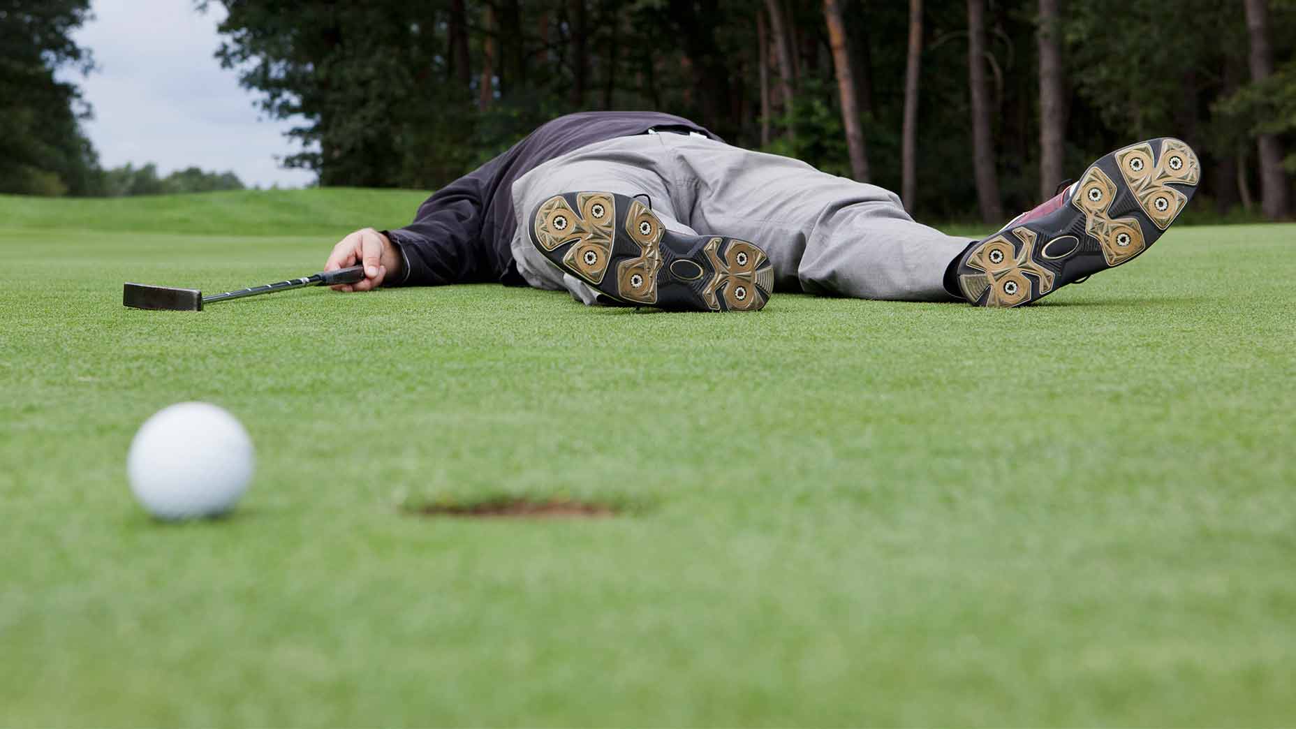 Golfer laying on the green.