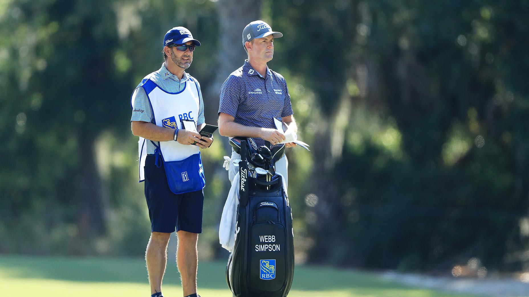 webb simpson stands next to caddie heritage