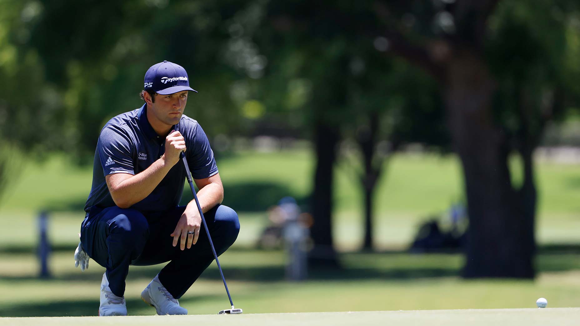 Jon Rahm reads a putt.