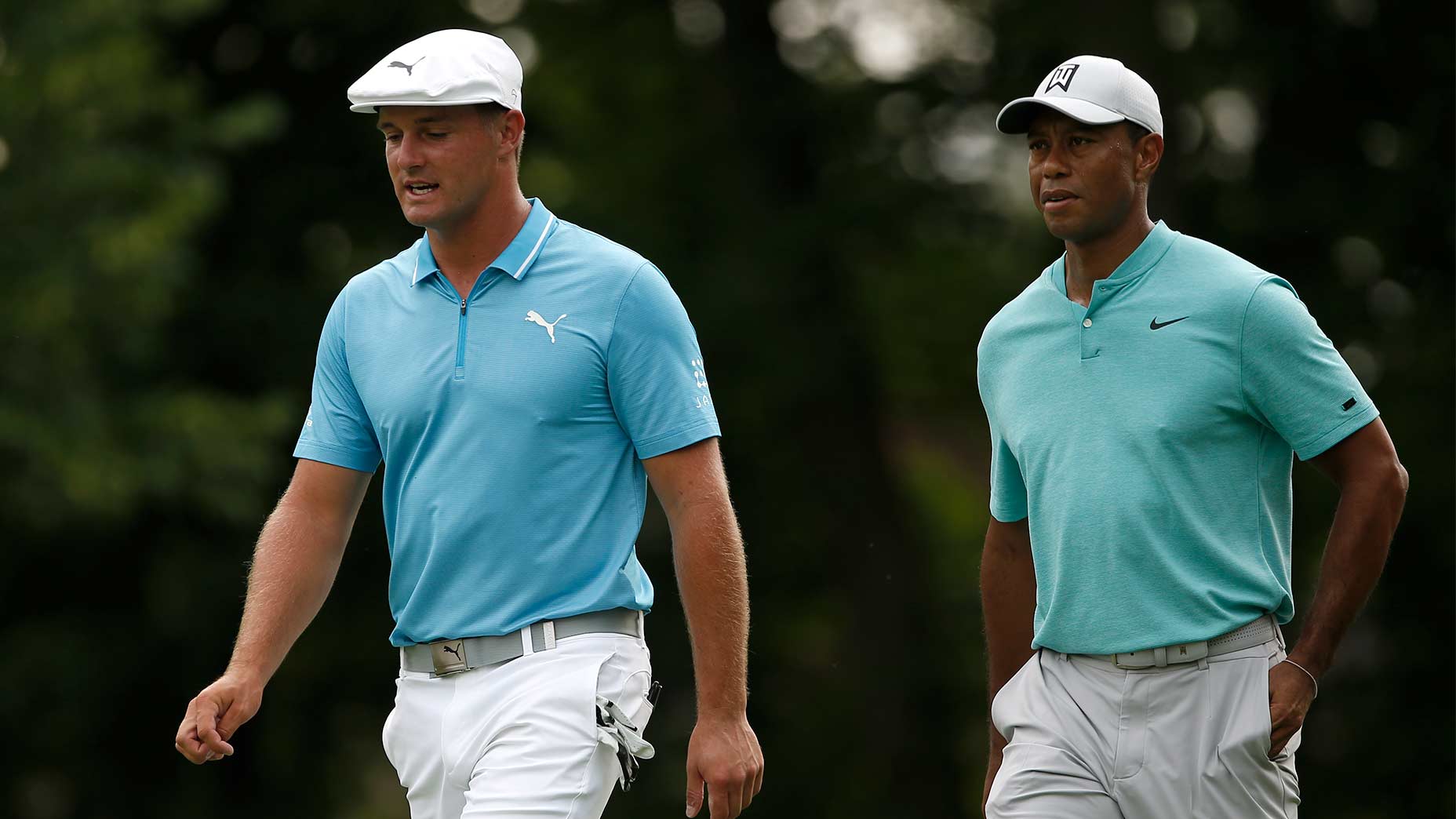 Tiger Woods and Bryson DeChambeau walk down the fairway.