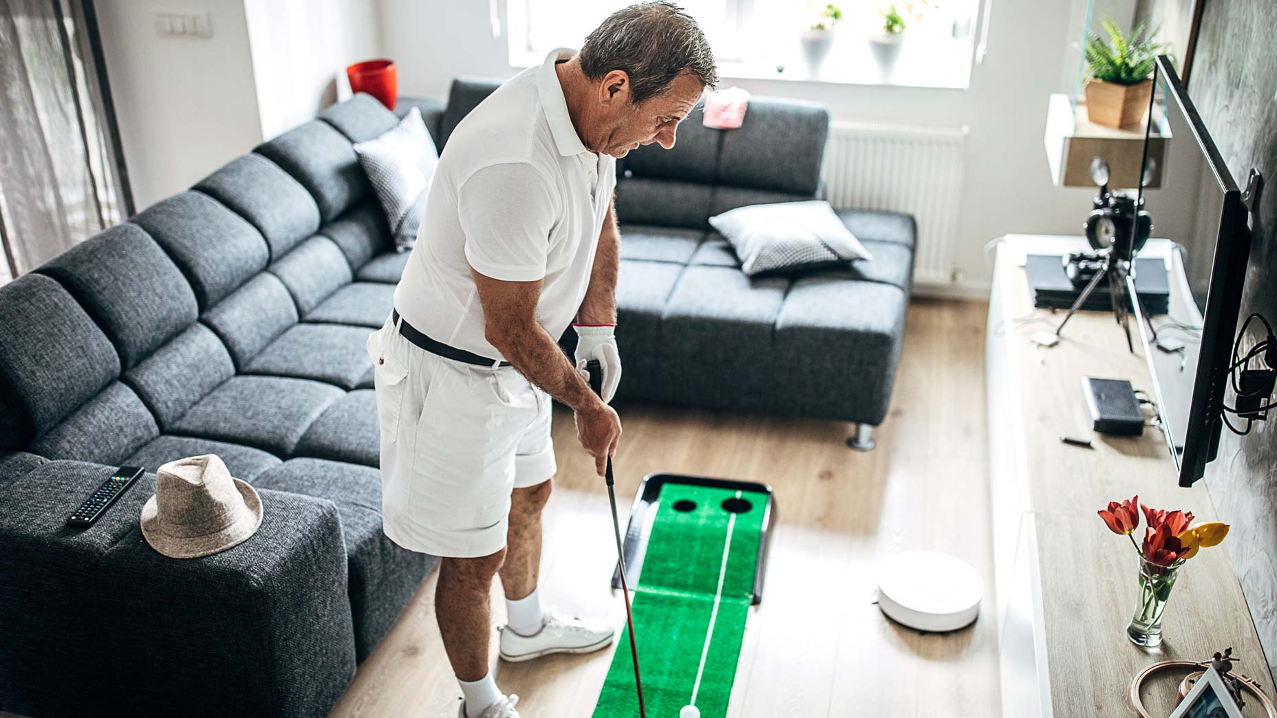 man practicing golf at home
