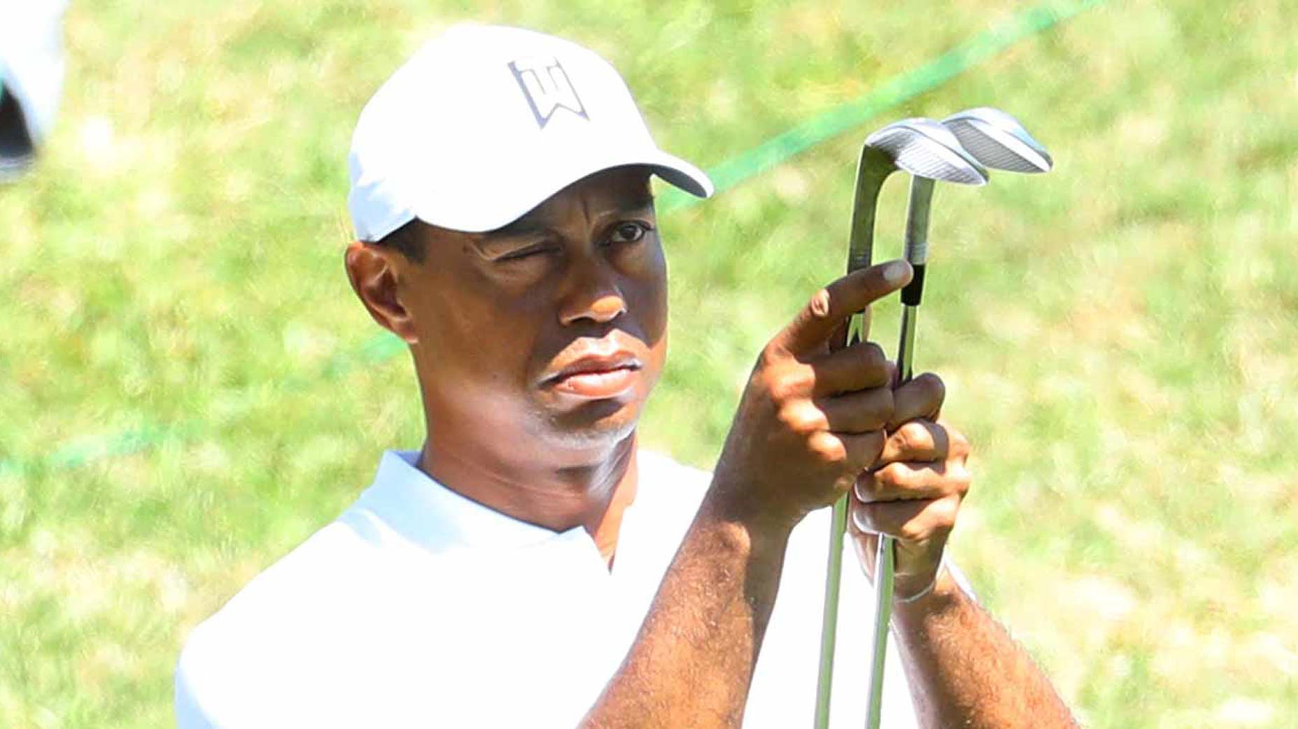 tiger woods inspects clubs