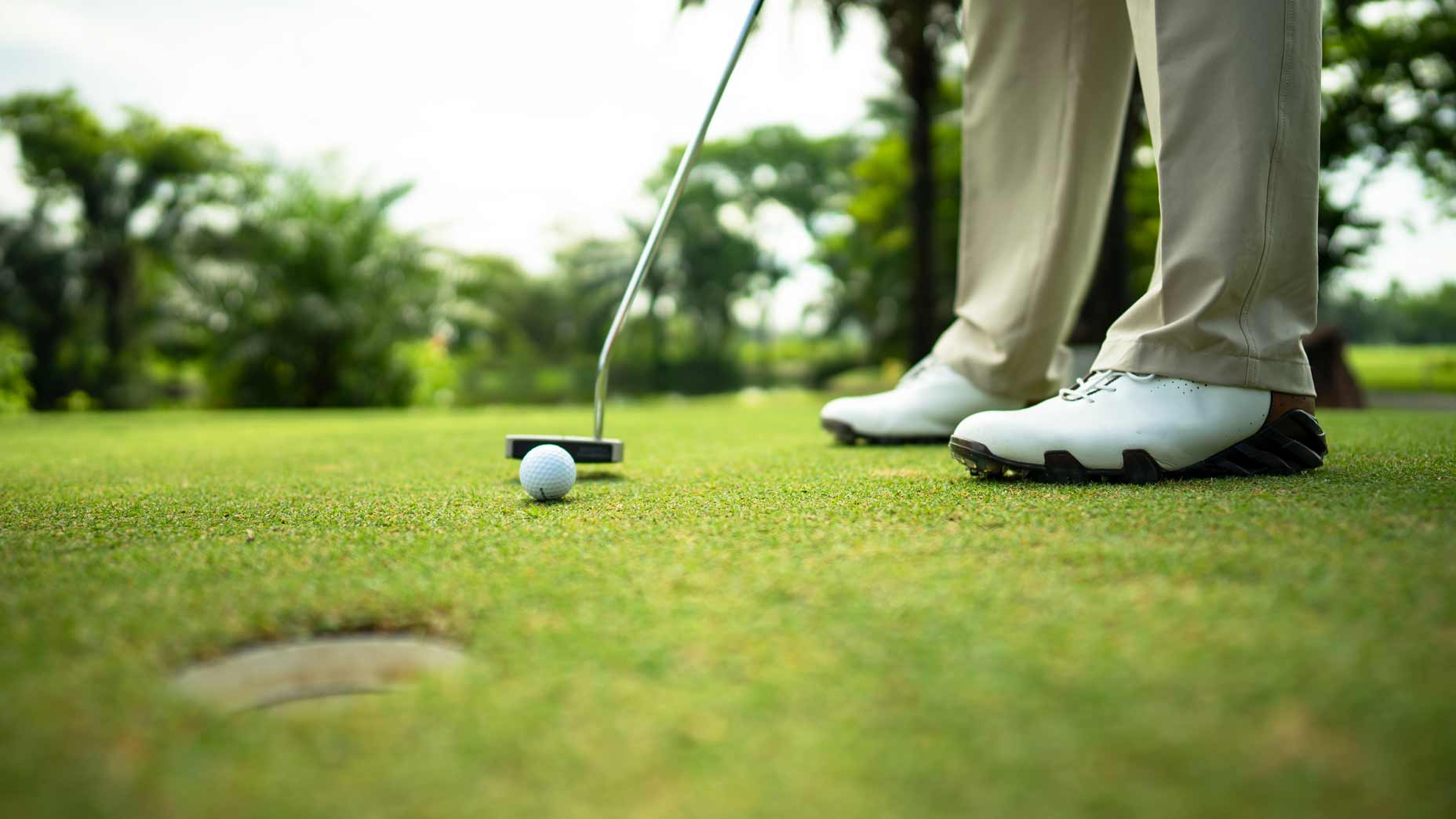 Putter hitting ball on green