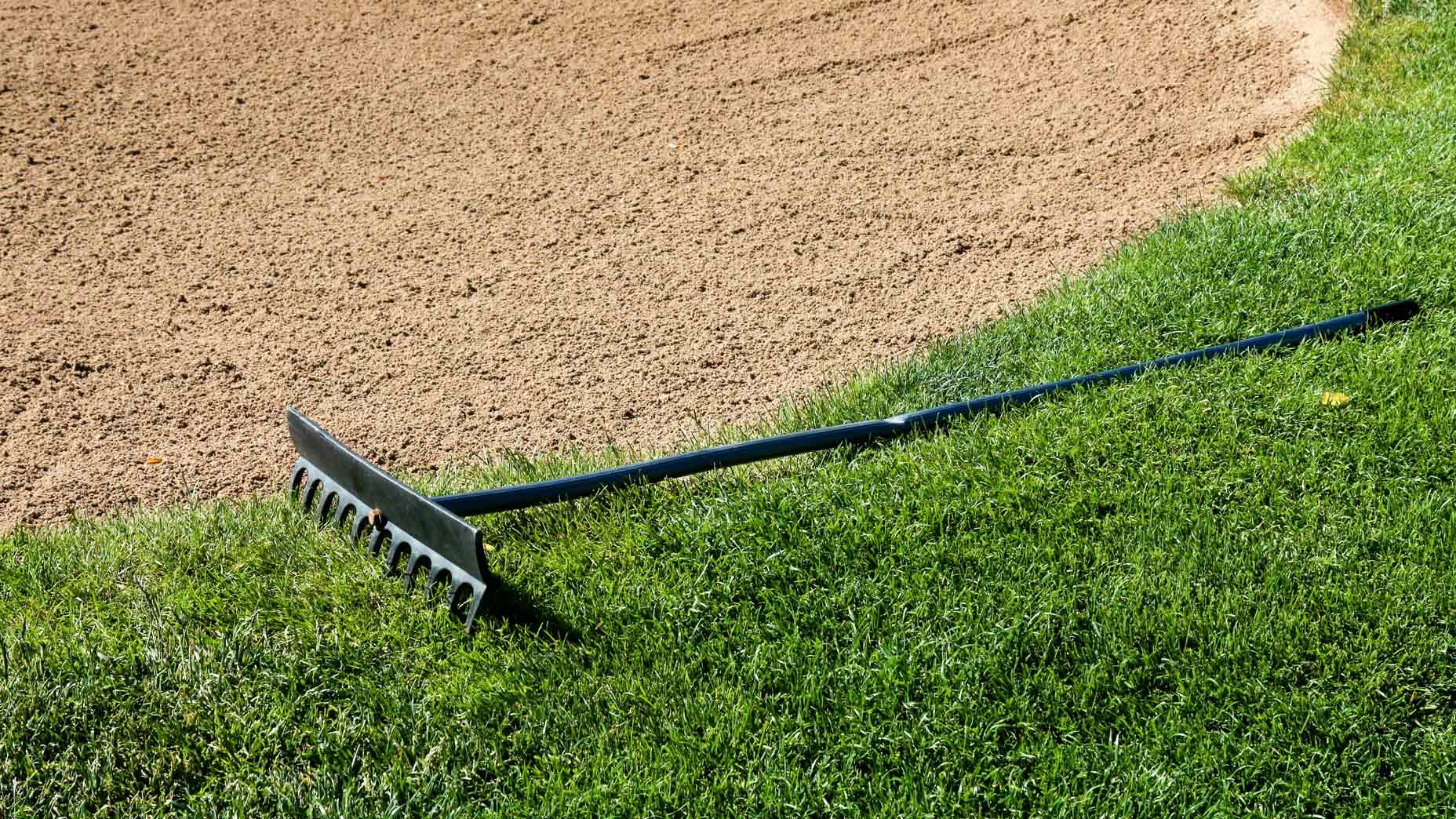 A rake left on the edge of a bunker