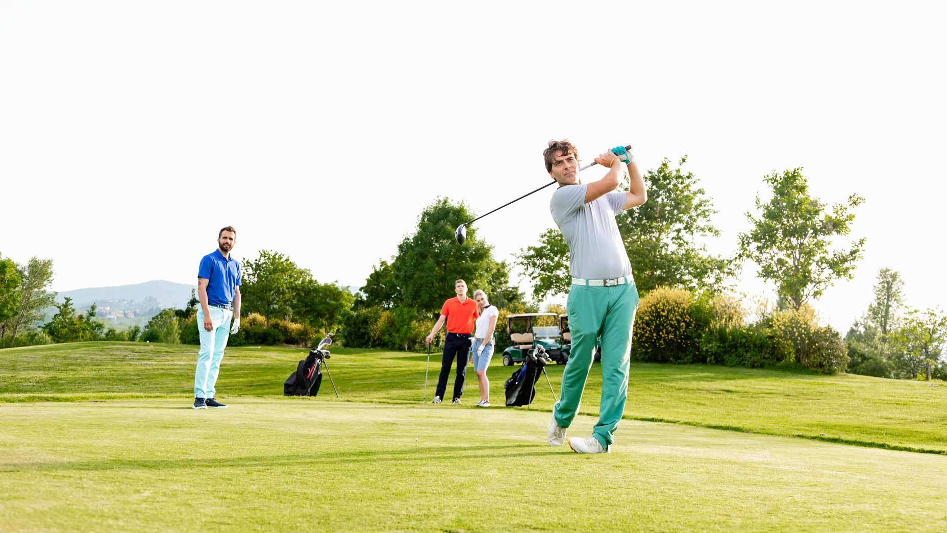 man hits golf ball