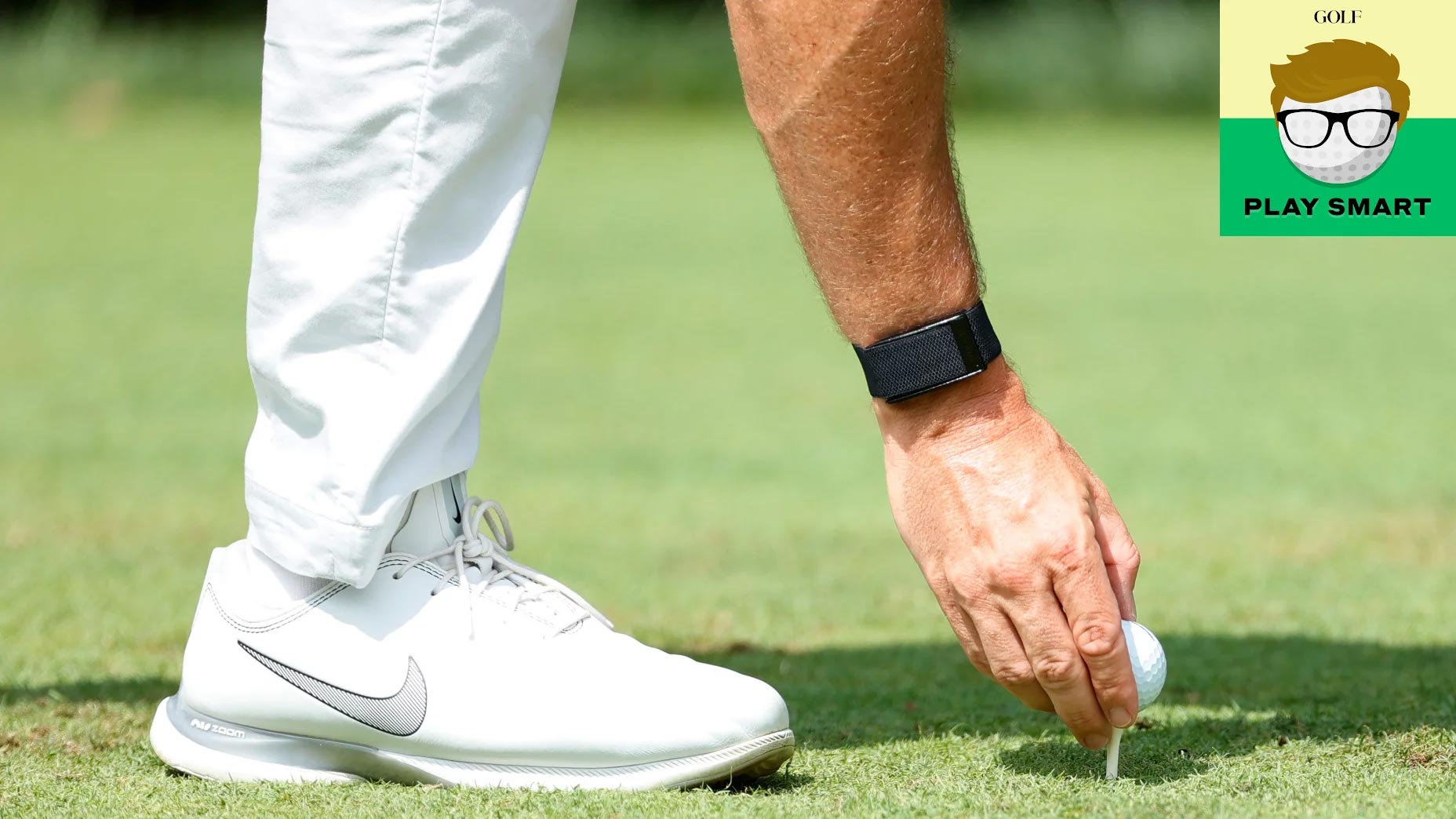Pro tees up golf ball
