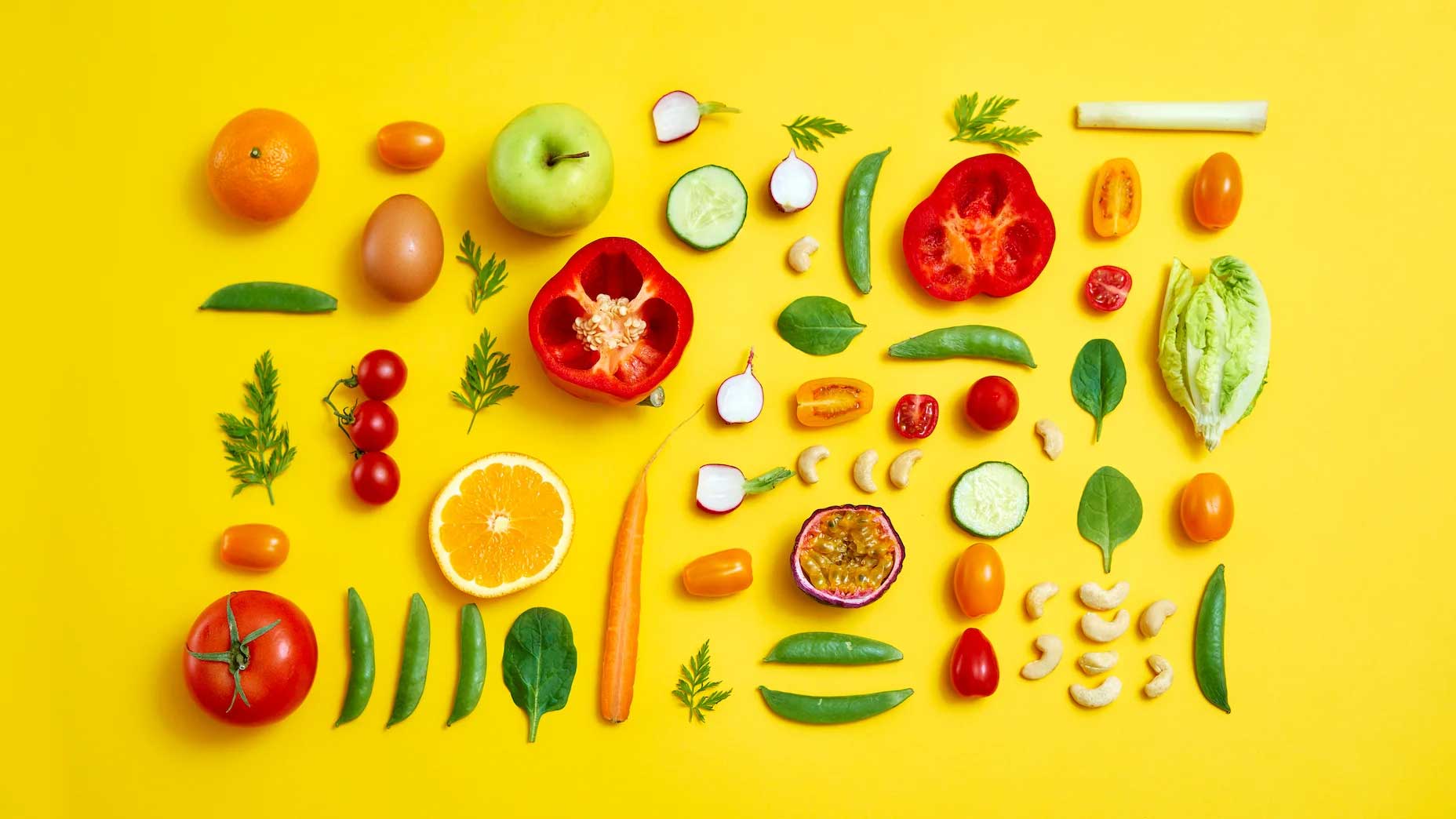 Fruits and vegetables laid on a yellow background