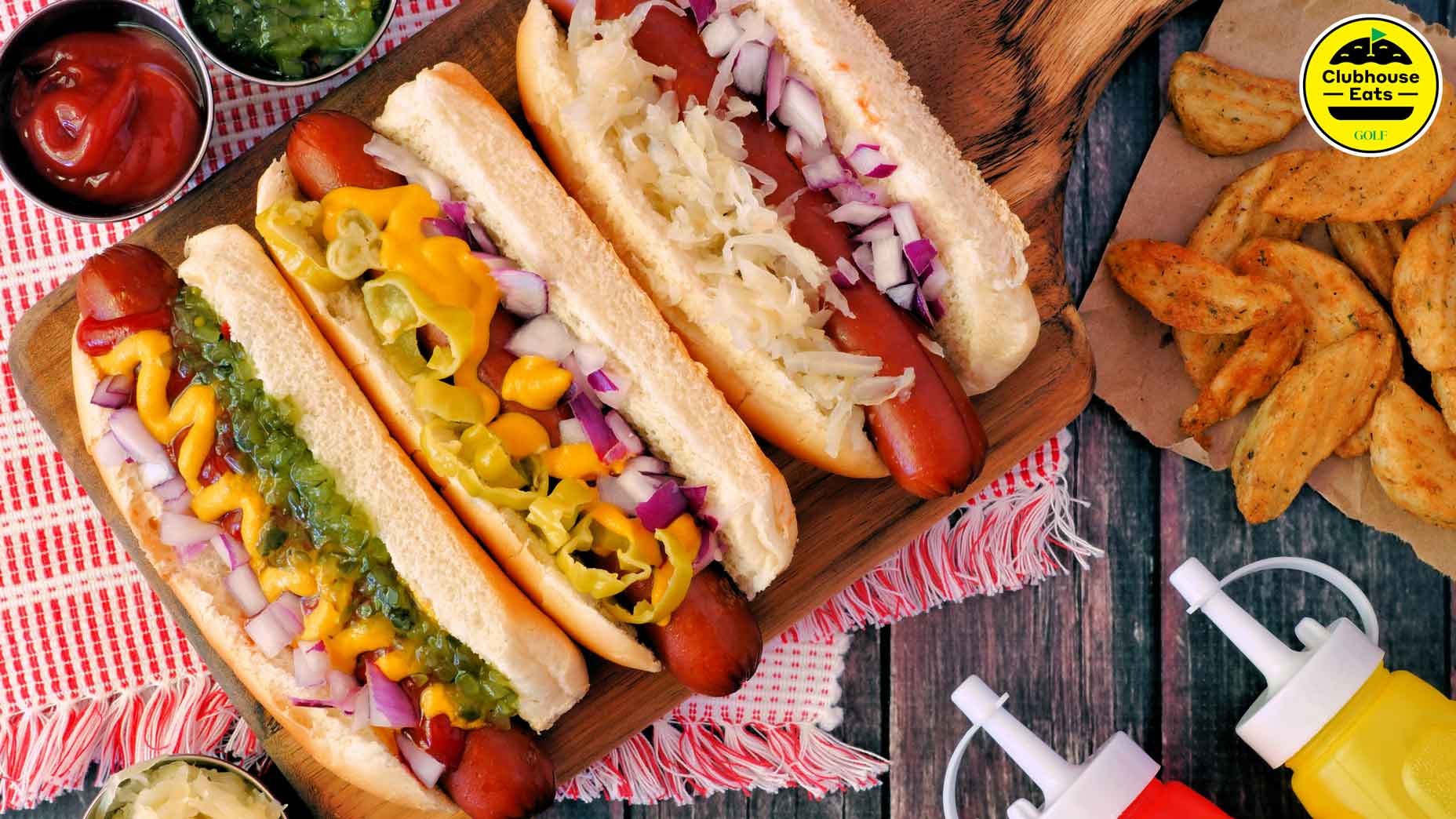 three hot dogs on a table with toppings