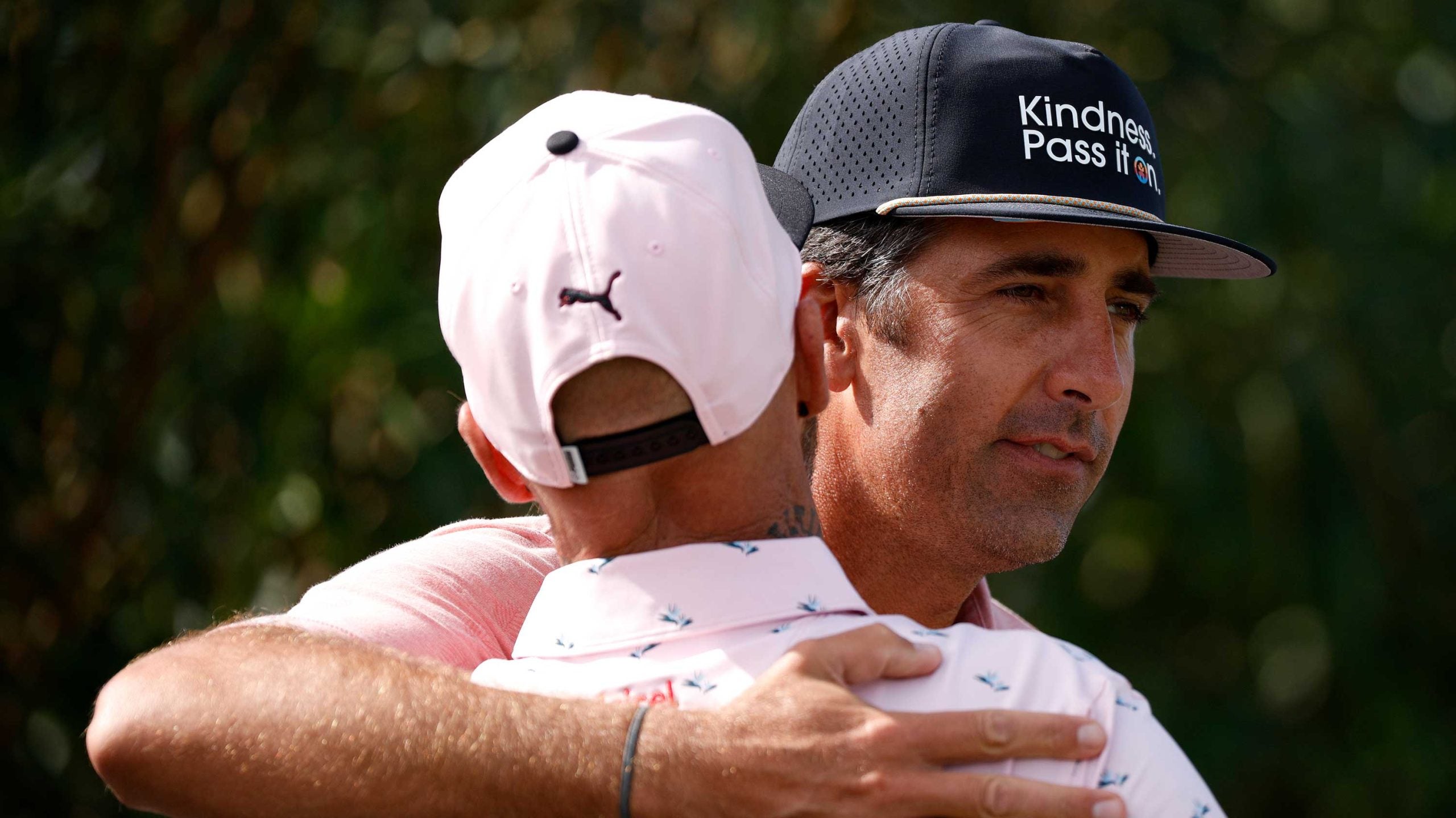 Golfers Michael Simms and Brian Morris of Bermuda hug before teeing off on the first hole during round one of the Butterfield Bermuda Championship at Port Royal Golf Course