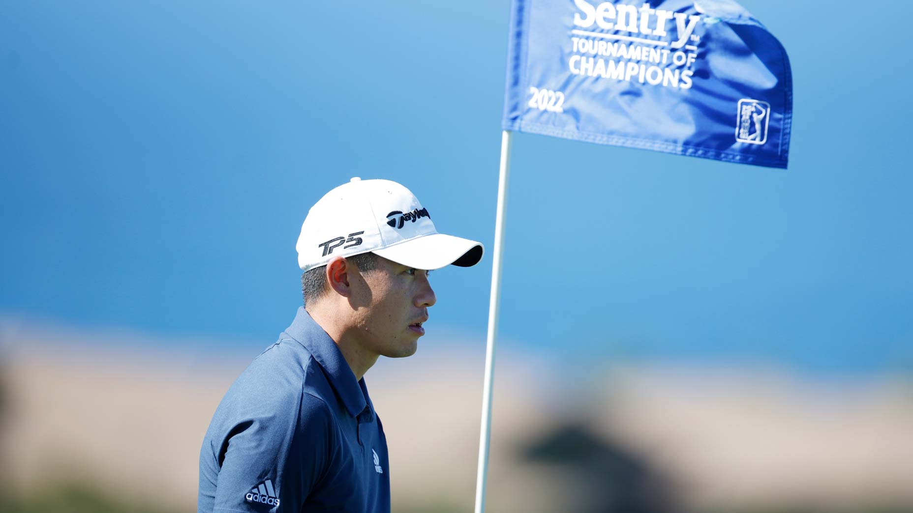 Colin Morikawa stands on golf green near flagstick at 2022 Tournament of Champions
