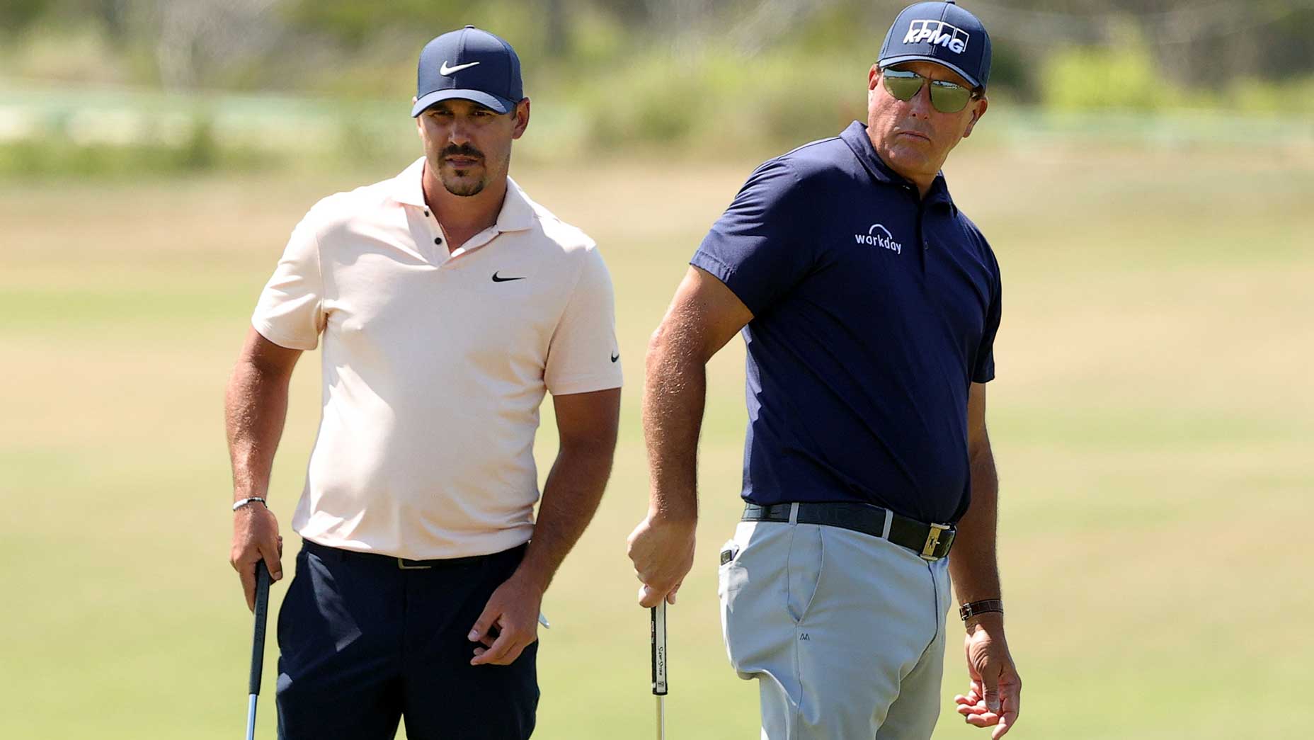 brooks koepka stands with phil mickelson
