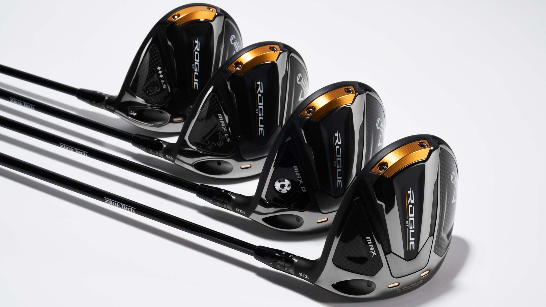 Four Callaway Rogue ST Max drivers laying on grey background