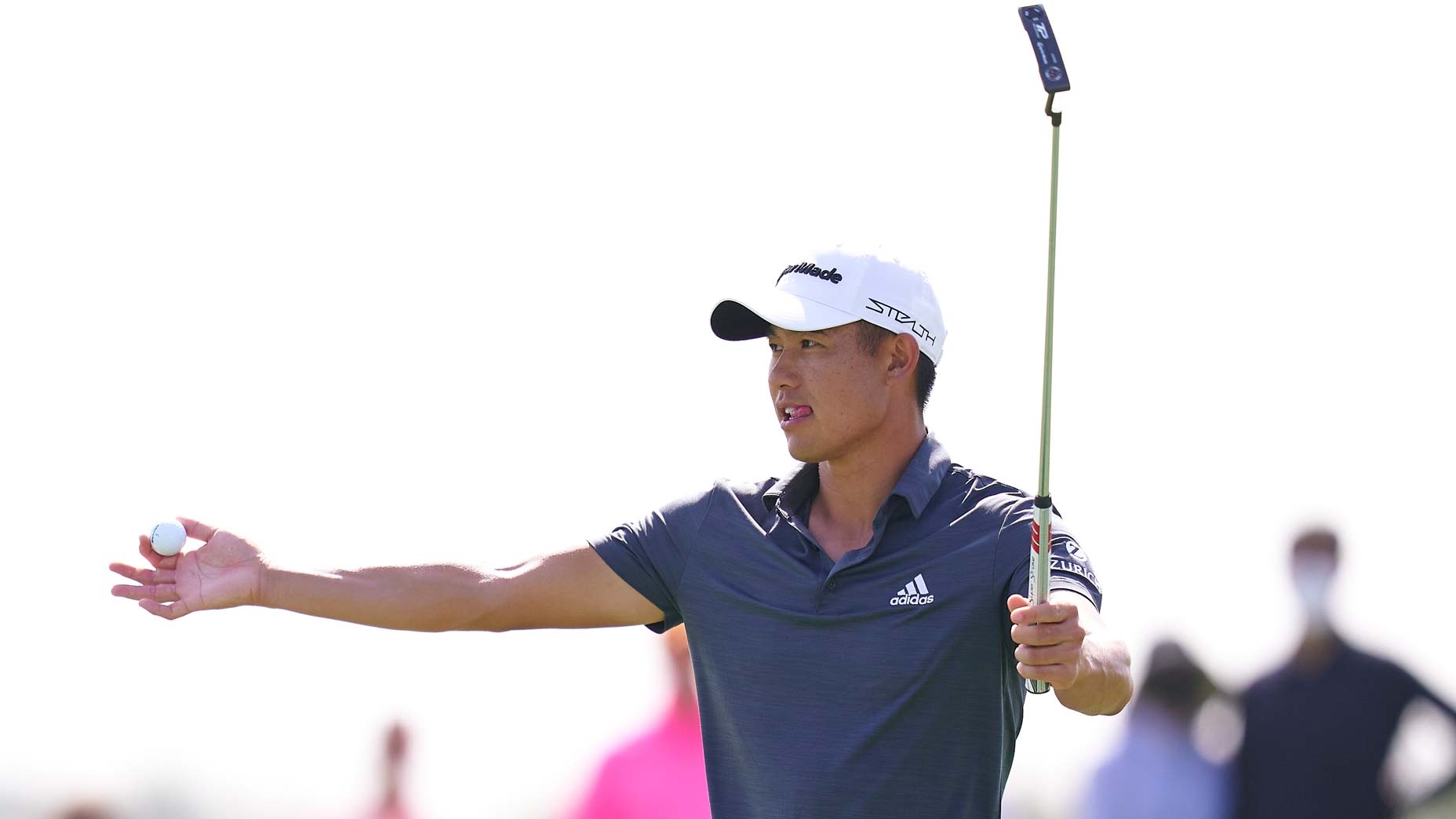 Collin Morikawa raises putter and hand at 2022 Dubai Desert Classic