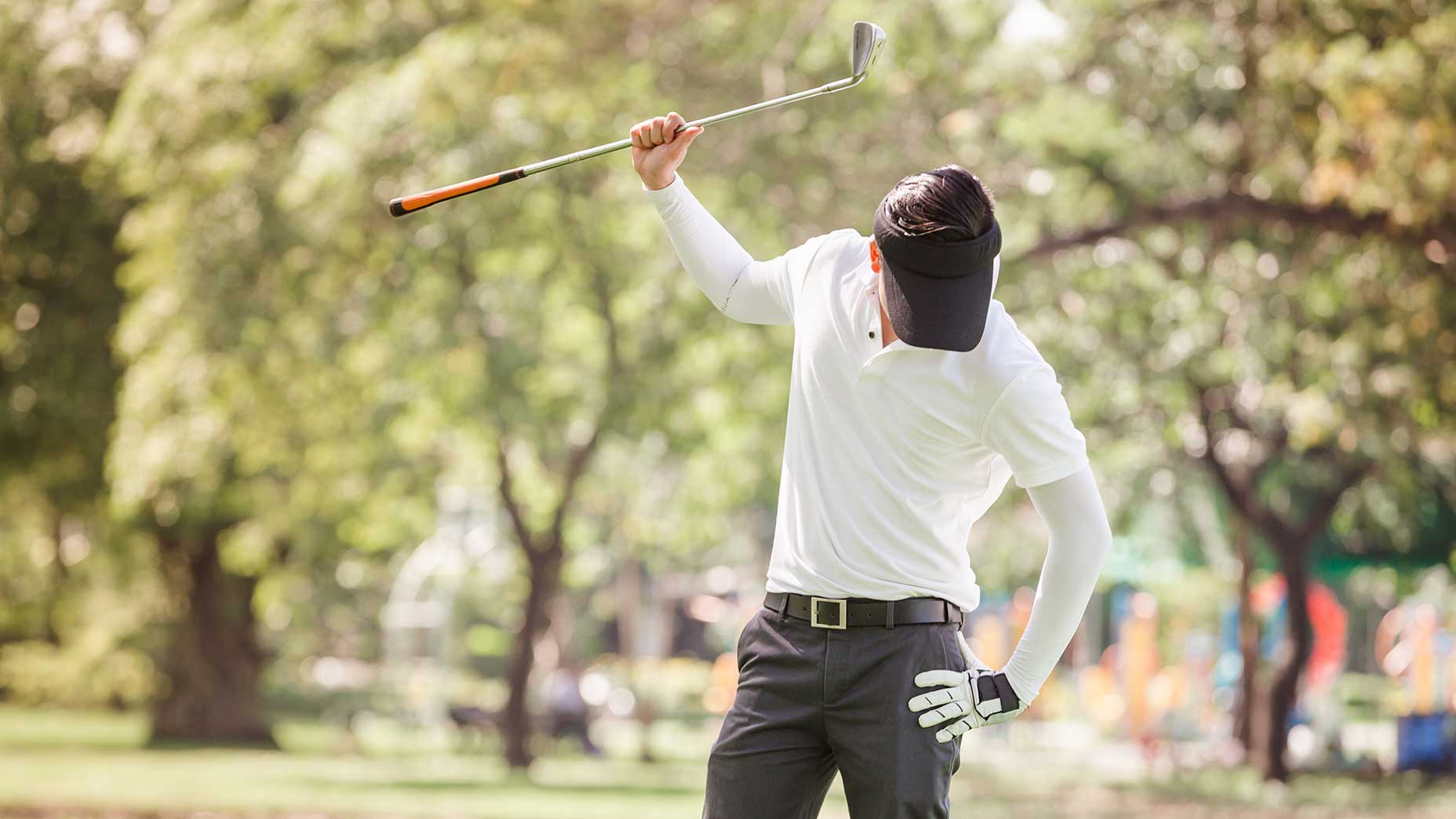 golfer in white shit looks down in disgust