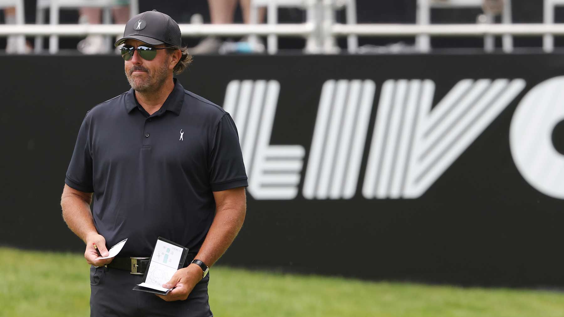 phil mickelson in front of LIV sign