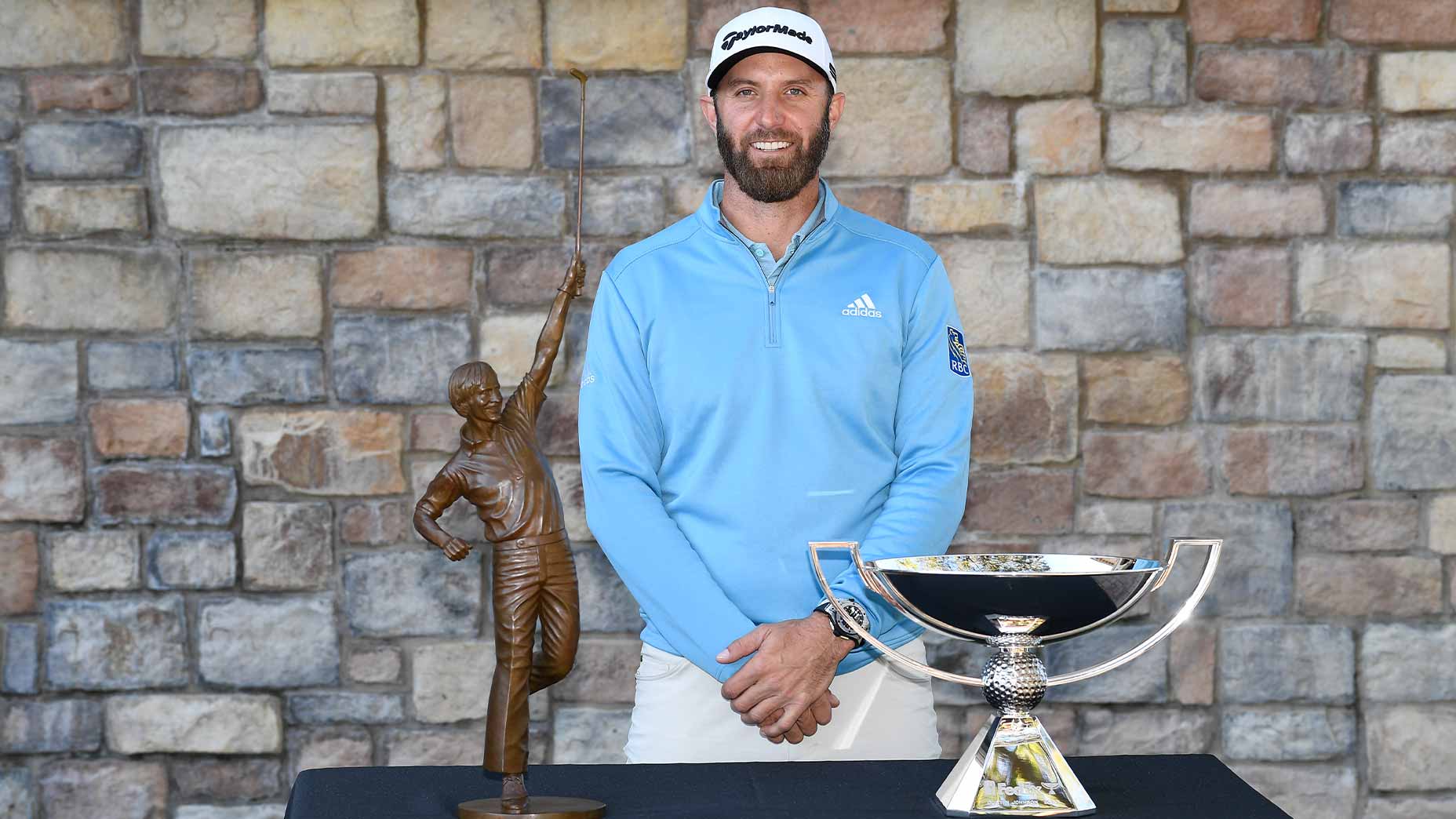 dustin johnson poses with award