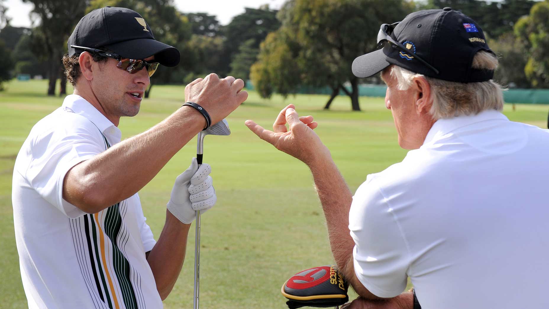 Australian Adam Scott (L) talks with team captain Greg Norman (R) during a practice round as the International team prepares to take on the US at the President's Cup tournament at the Royal Melbourne golf course, in Melbourne on November 16, 2011.