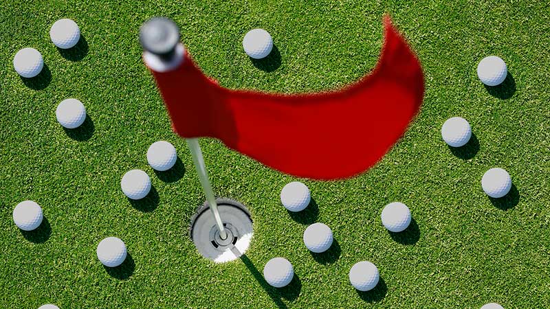 a green with golf balls on it