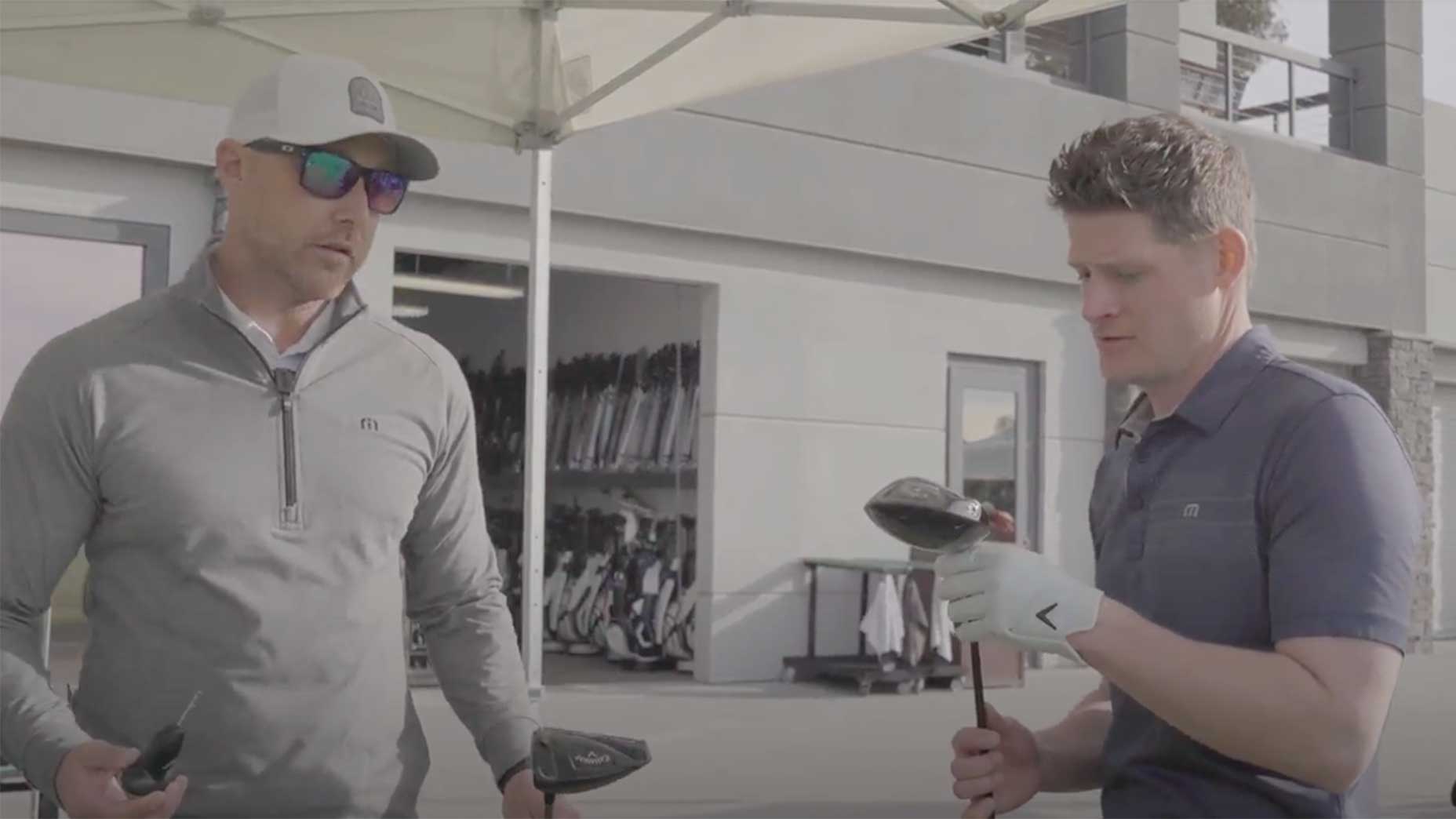 Golfers look at golf clubs.