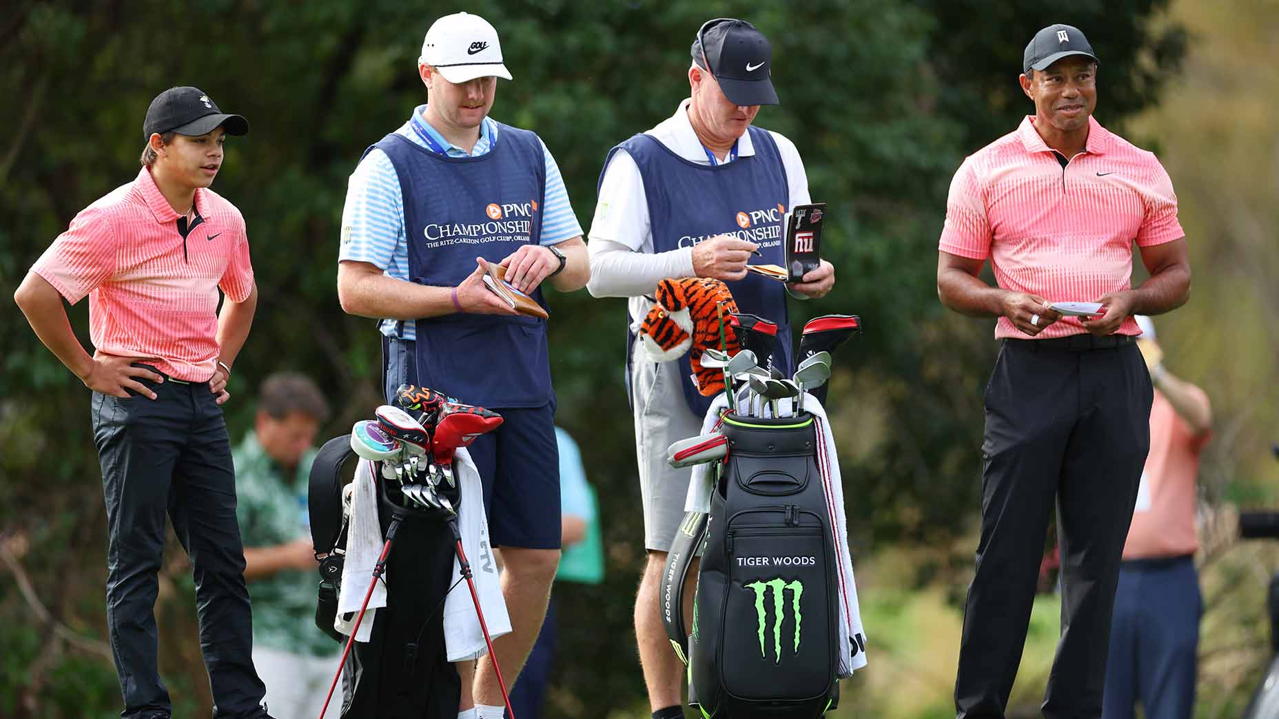 Tiger and Charlie woods with their caddies at the pnc championship.