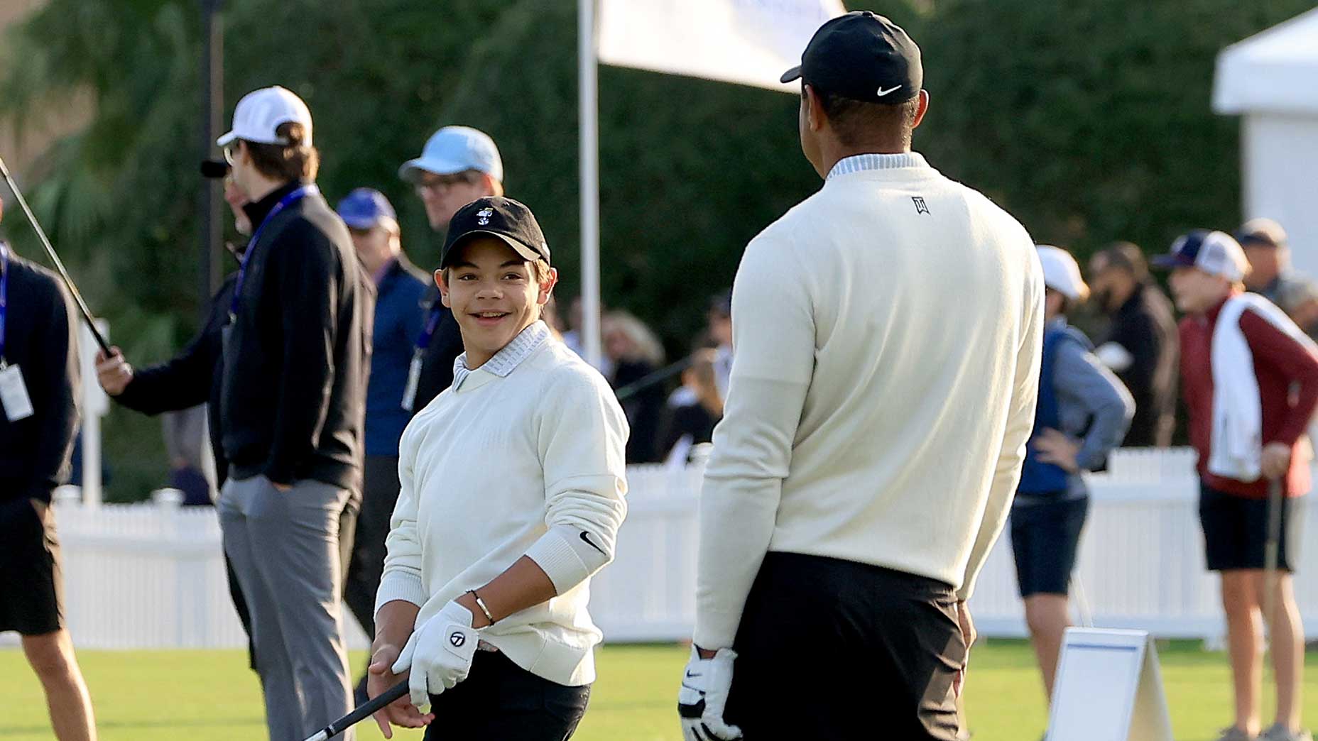 Charlie Woods smiles at his dad, Tiger Woods, on the driving range.