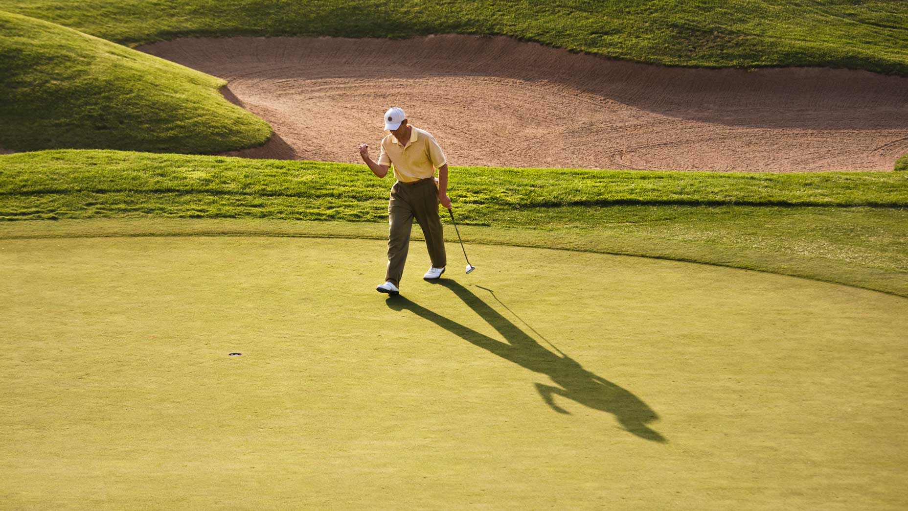 golfer fist pumps on a green