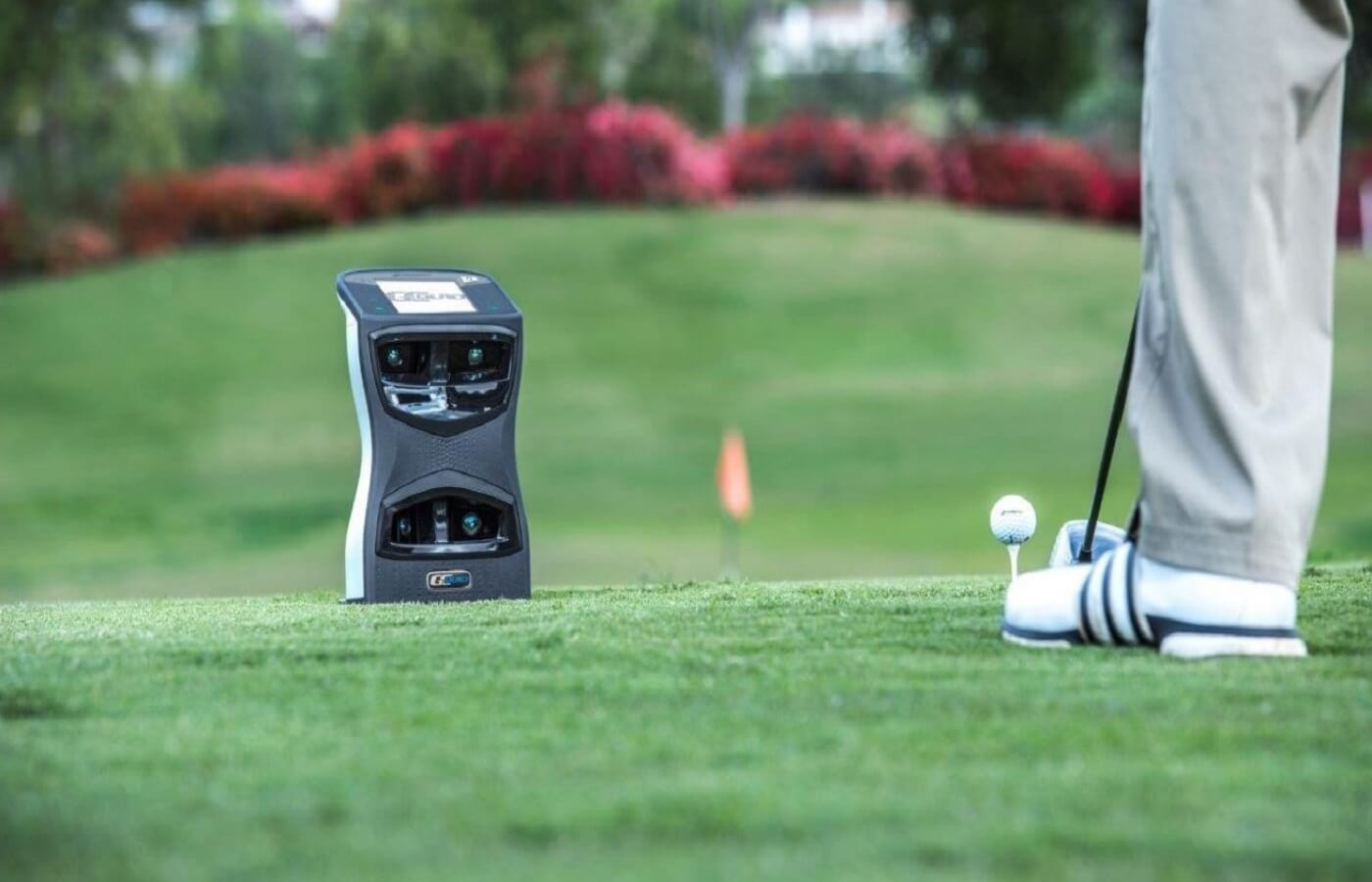 Golfer hitting a ball in front of a golf swing analyzer