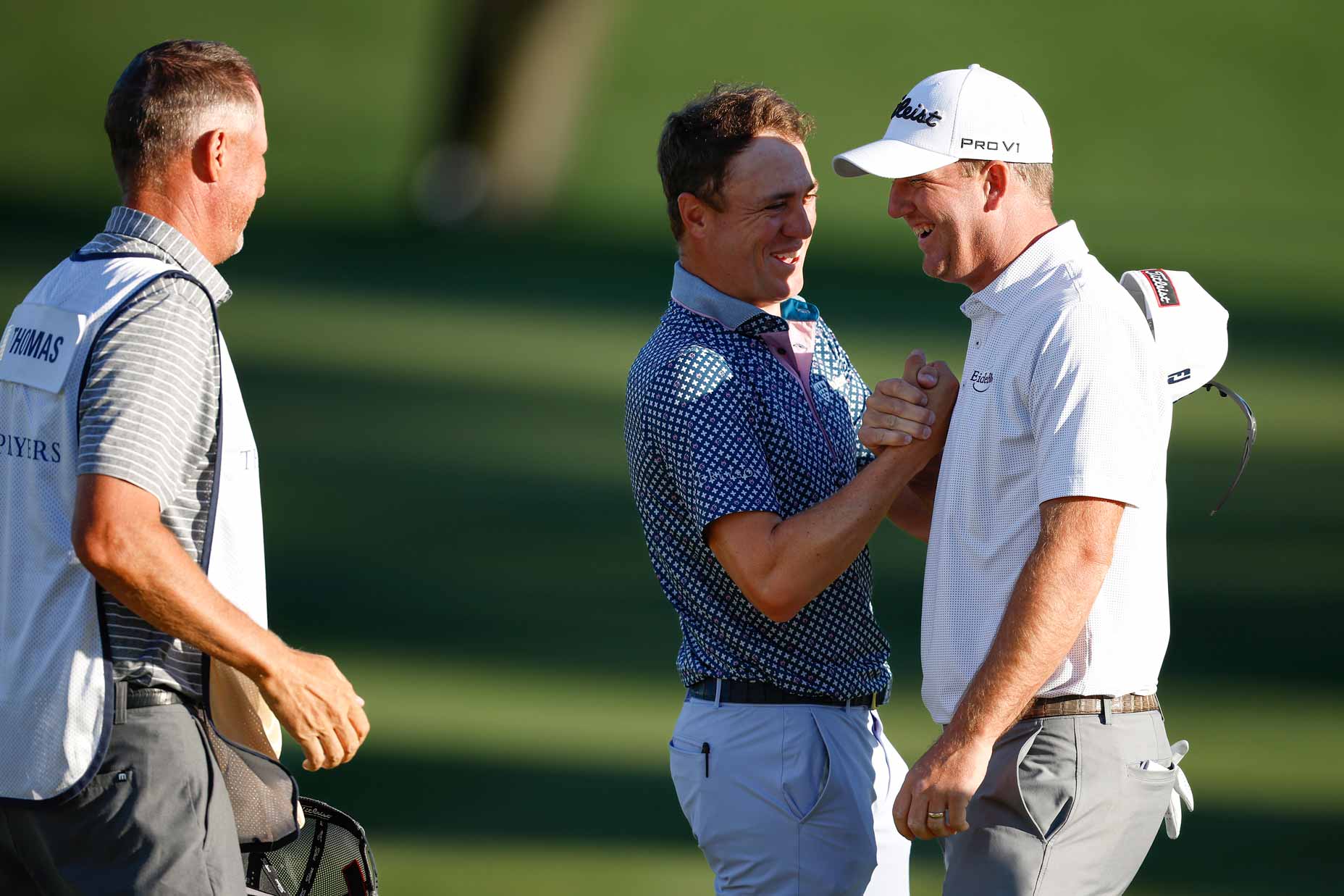 Caddie Jim 'Bones' Mackay and Justin Thomas of the United States congratulate Tom Hoge of the United States on the ninth green after his course record 62 during the third round of THE PLAYERS Championship on THE PLAYERS Stadium Course at TPC Sawgrass on March 11, 2023 in Ponte Vedra Beach, Florida.