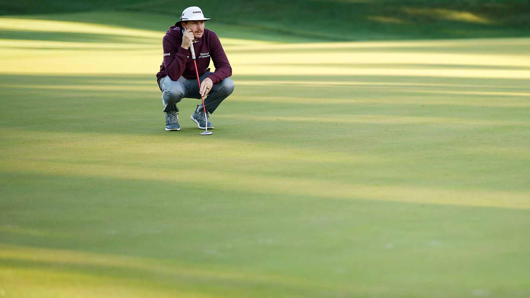 joel dahmen crouches over putt