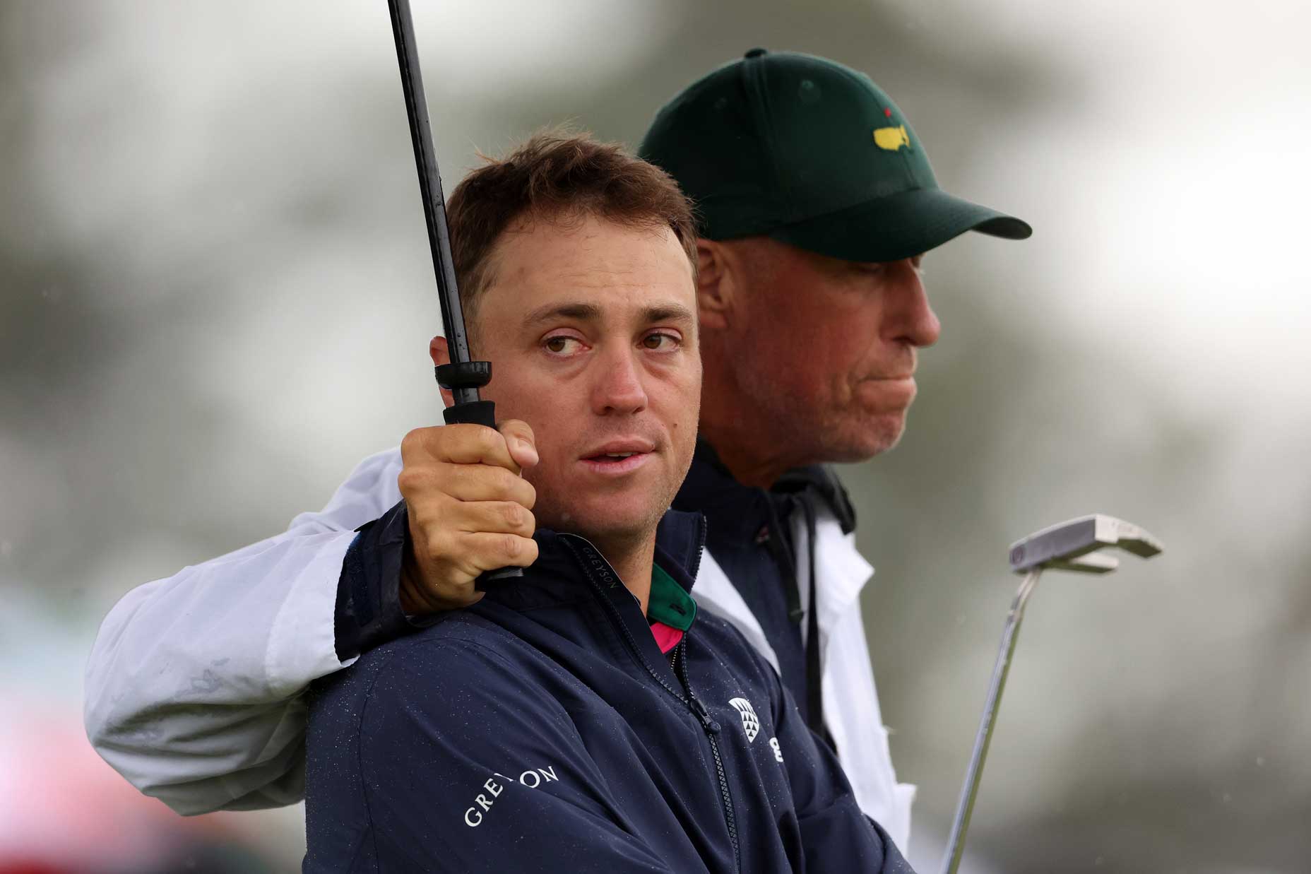 Justin Thomas of the United States and his caddie Jim 'Bones' Mackay react to his bogey on the 18th green during the continuation of the weather delayed second round of the 2023 Masters Tournament at Augusta National Golf Club on April 08, 2023 in Augusta, Georgia.