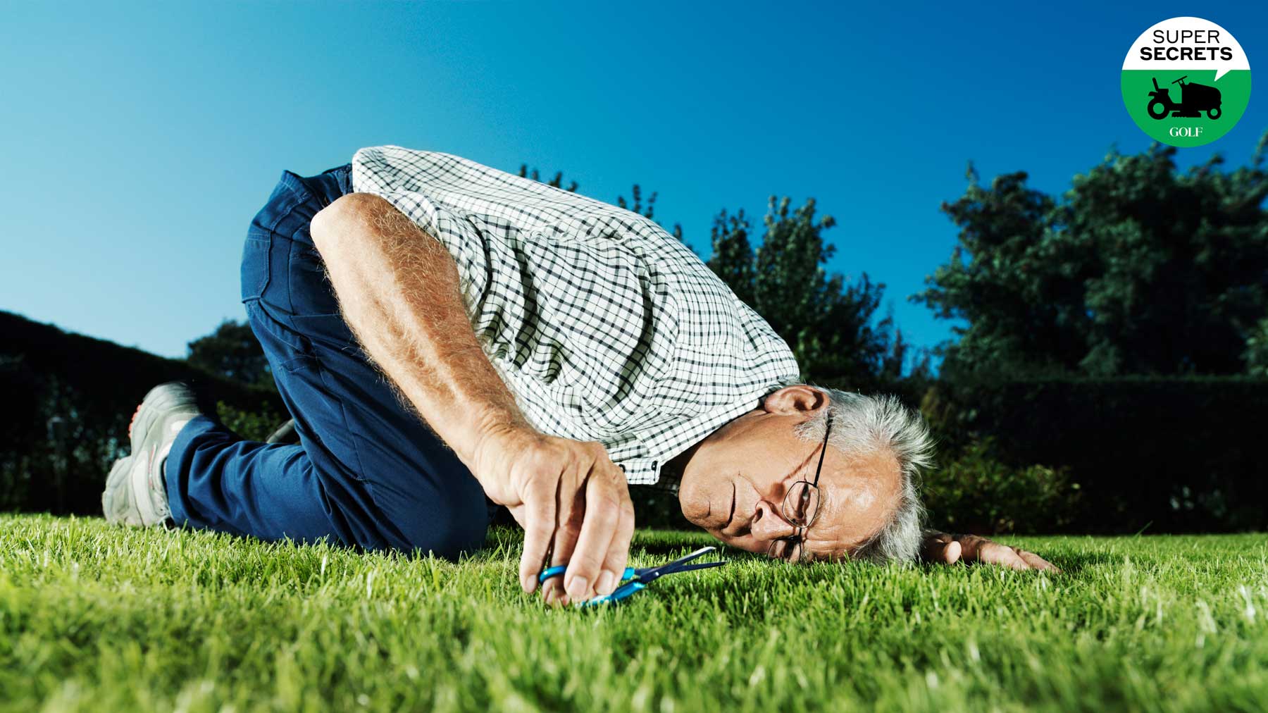 man cutting grass with scissors