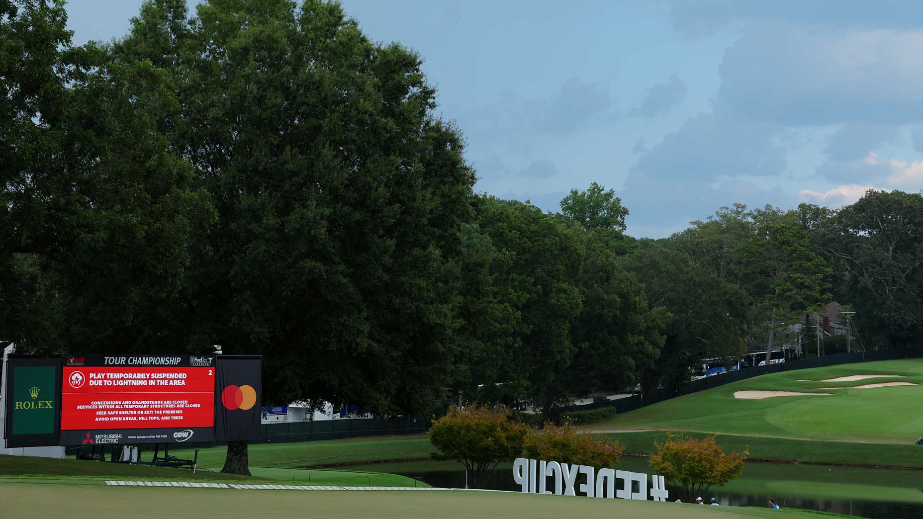 A leaderboard displays a message indicating a suspension of play due to inclement weather during the third round of the TOUR Championship at East Lake Golf Club on August 26, 2023 in Atlanta, Georgia.