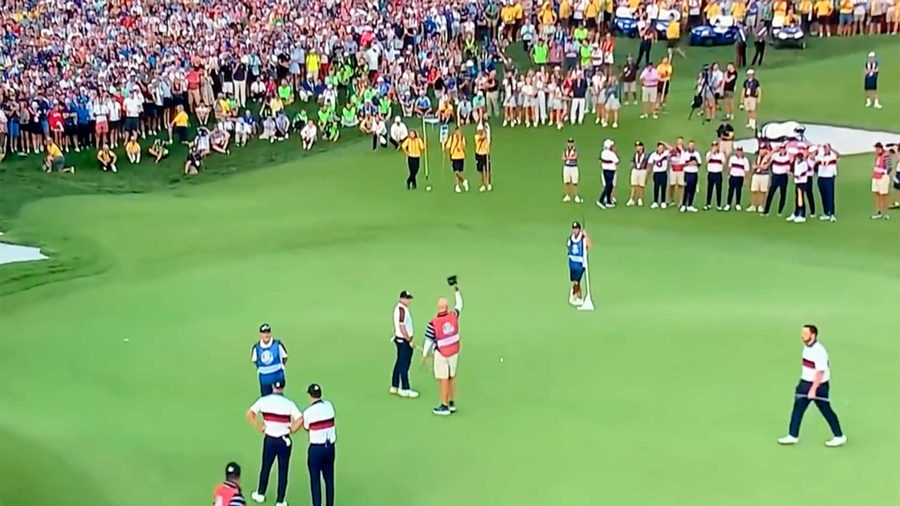 Rory McIlroy and Joe LaCava, the caddie for Patrick Cantlay, exchange words on the 18th green on Saturday at the Ryder Cup.