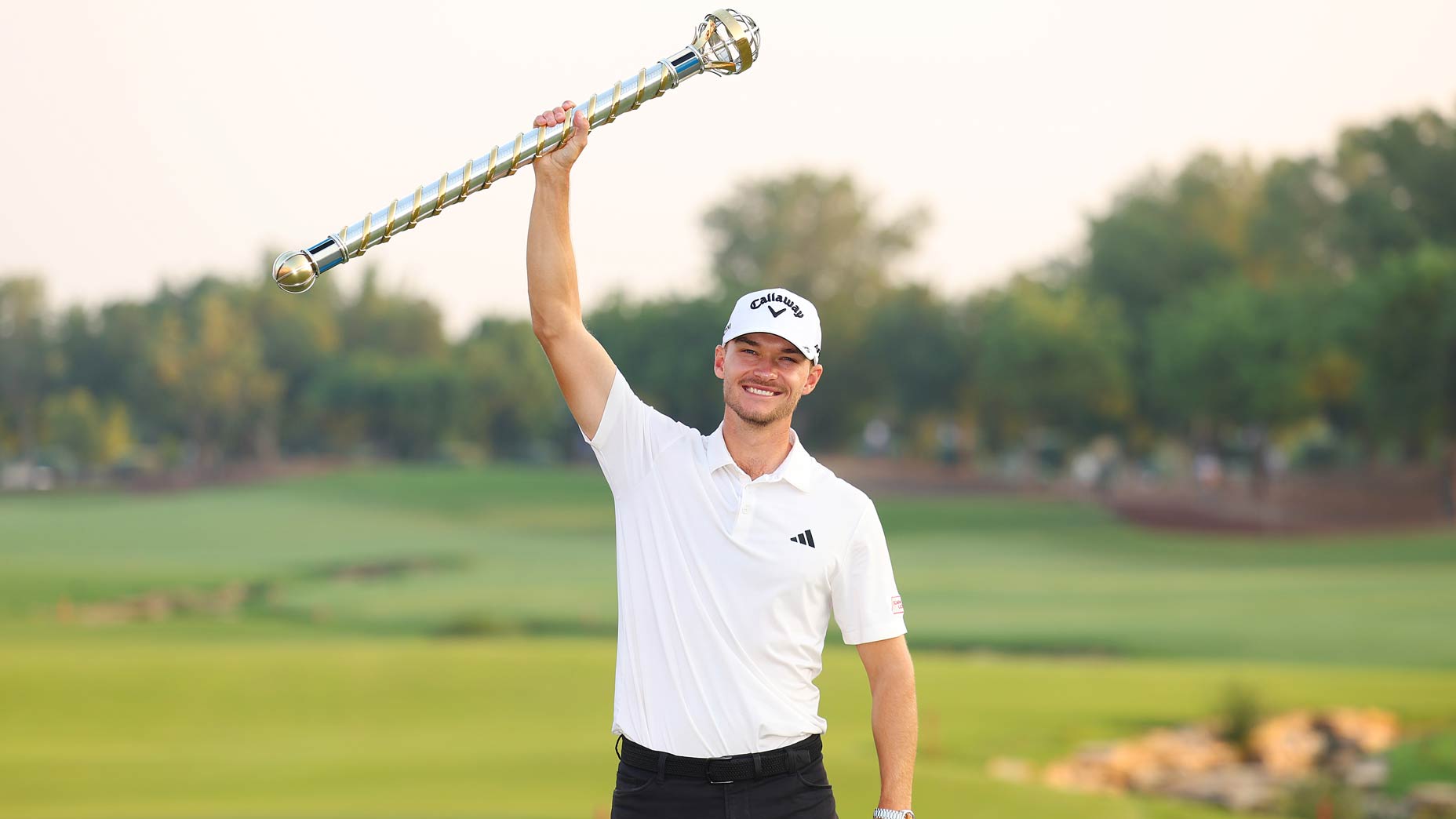 Nicolai Hojgaard raises the DP World Tour Championship trophy.