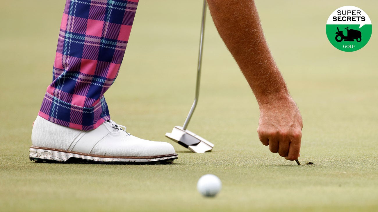 golfer repairing ball mark at augusta national